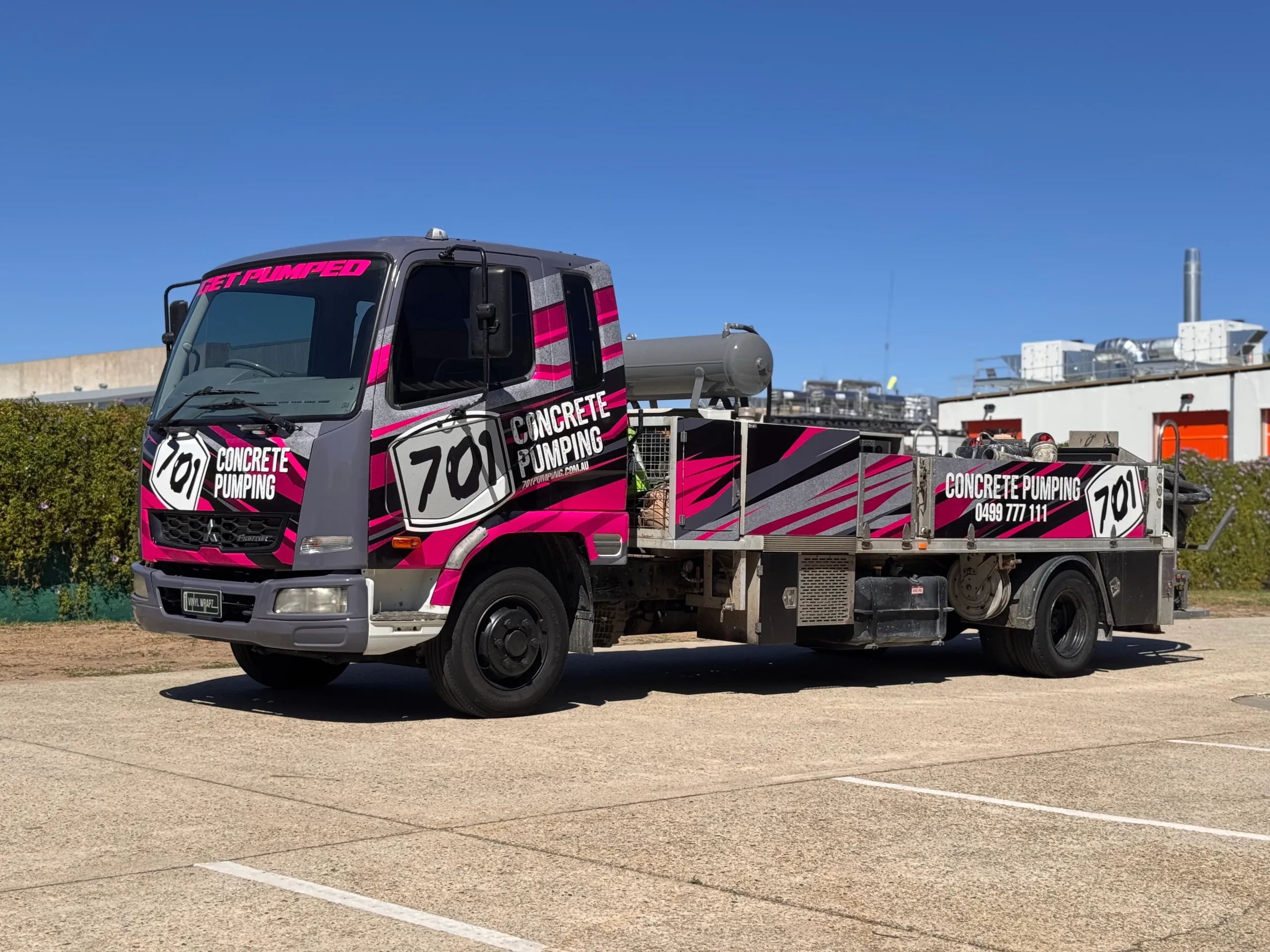 701 Concrete Pumping Mitsubishi Fighter truck with pink, grey and black graphics outdoors