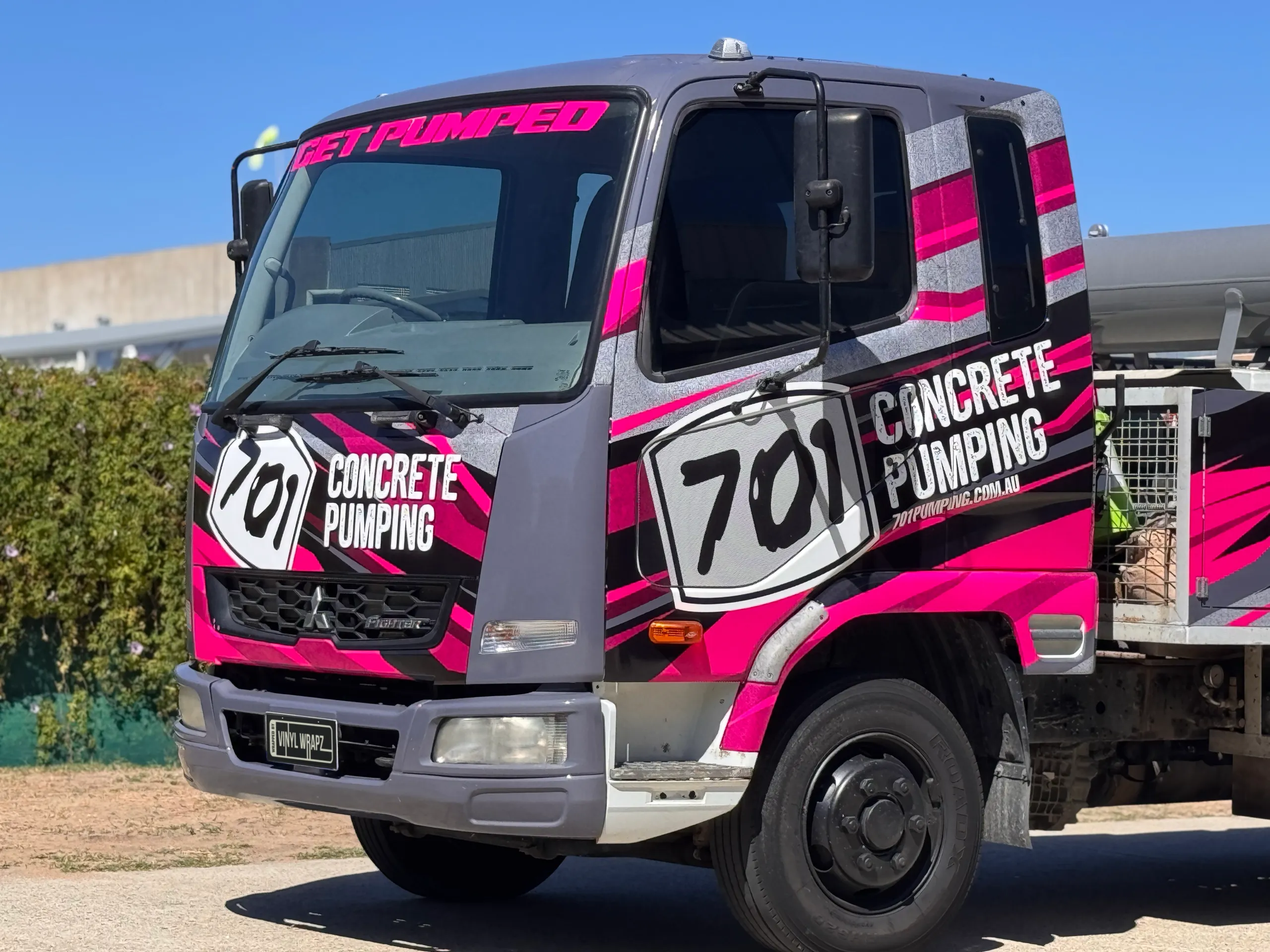 Pink, grey and black 701 Concrete Pumping branding across the Mitsubishi Fighter cab