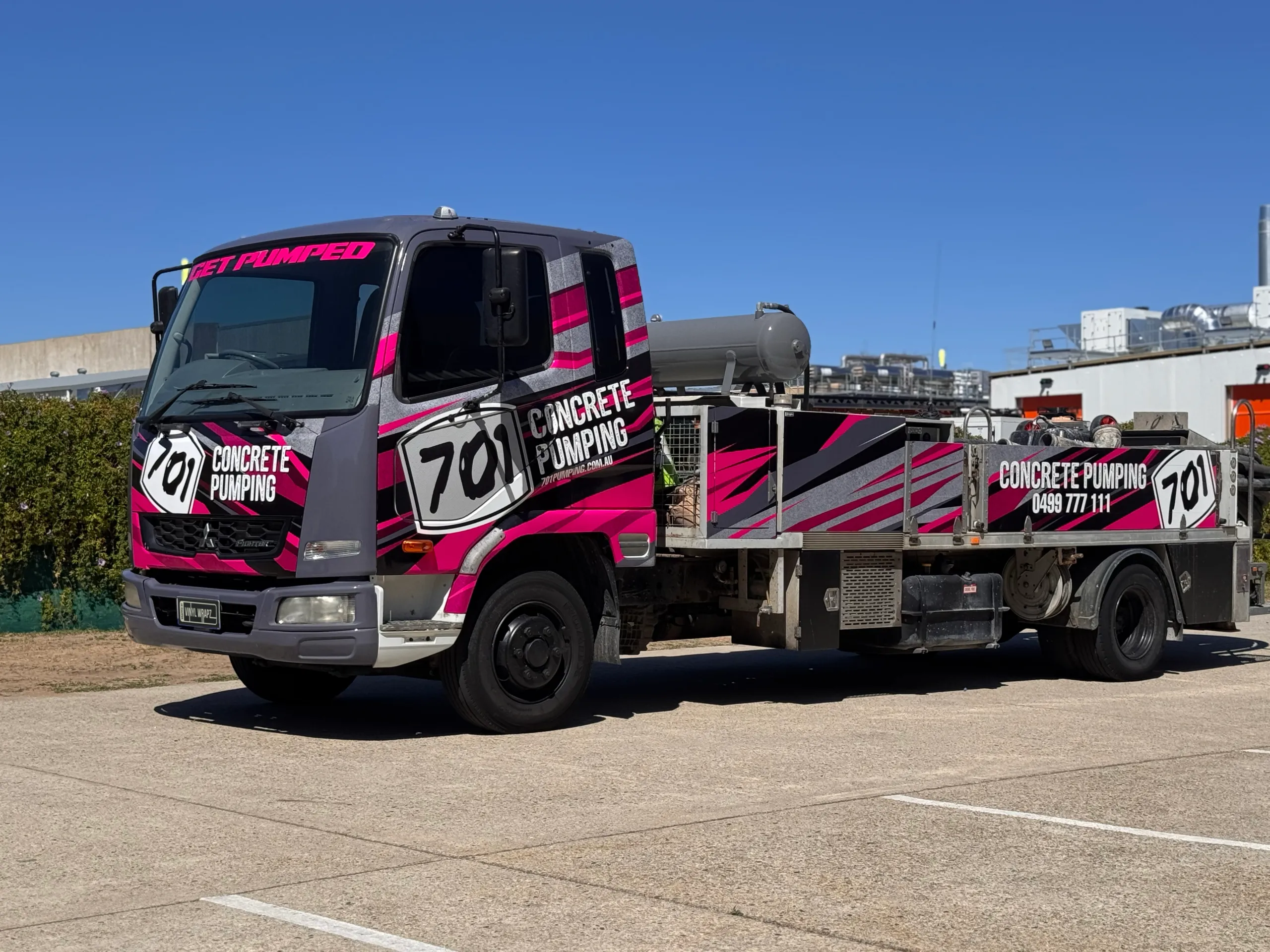 Wide front-quarter view of the 701 Concrete Pumping truck outside the workshop