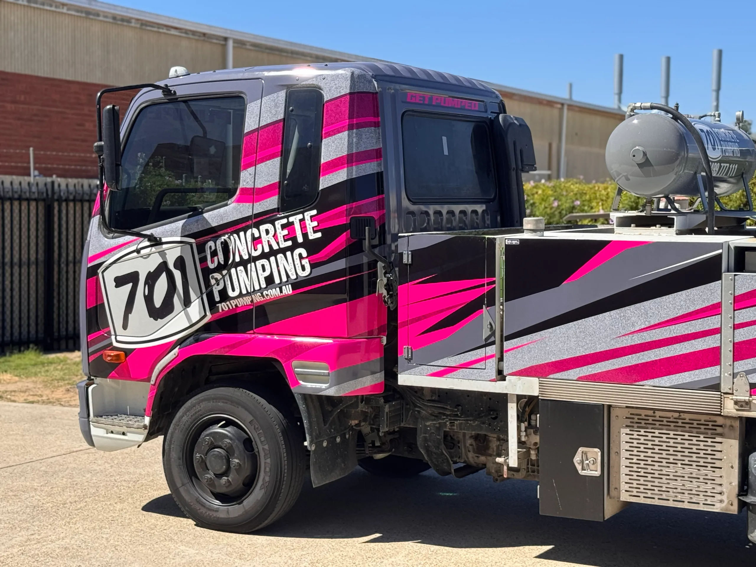 Side detail of the 701 Concrete Pumping cab and equipment body with matching pink and grey graphics