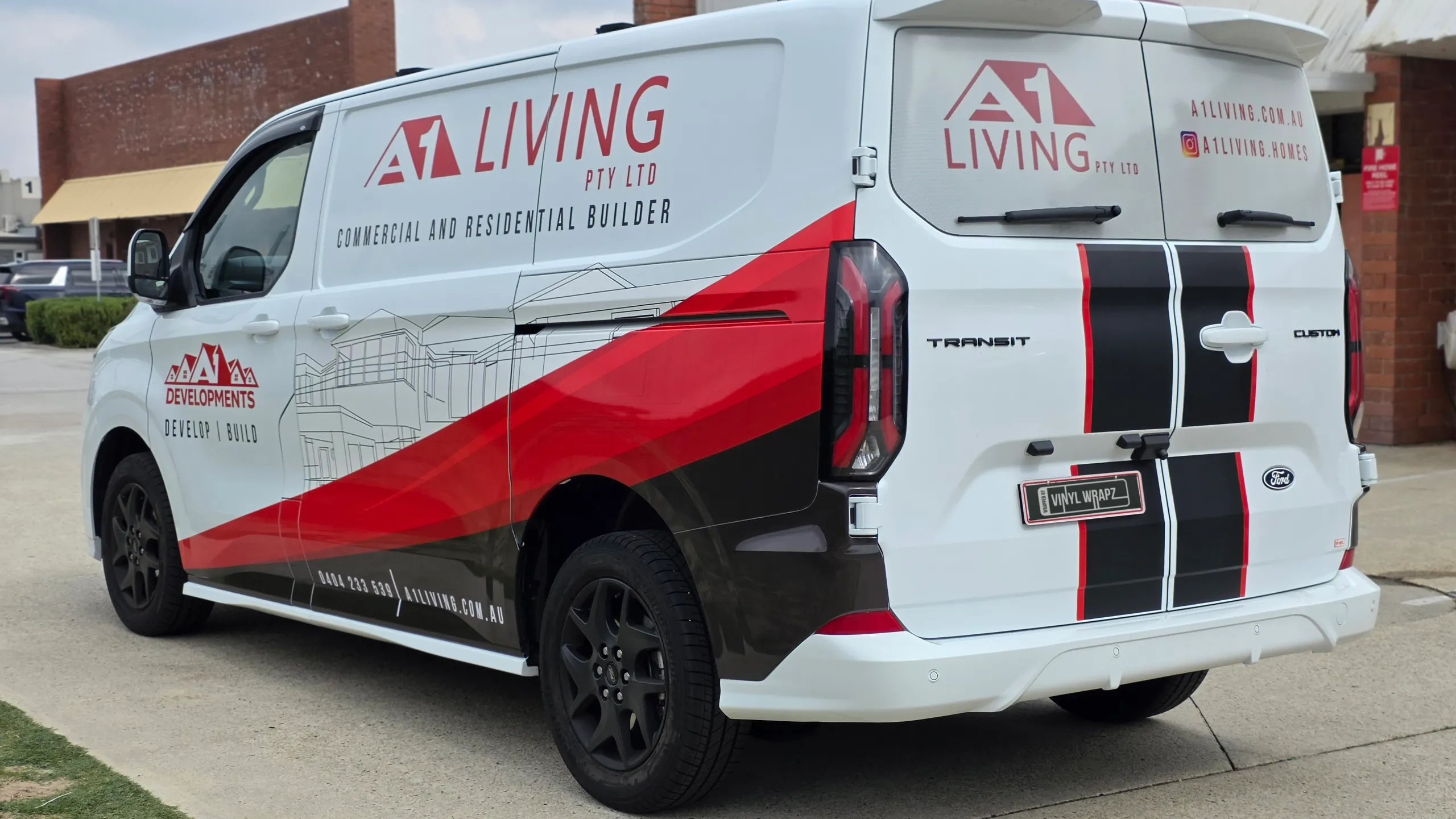 Rear-quarter view of the A1 Living Ford Transit Custom showing its side graphics and rear-door branding