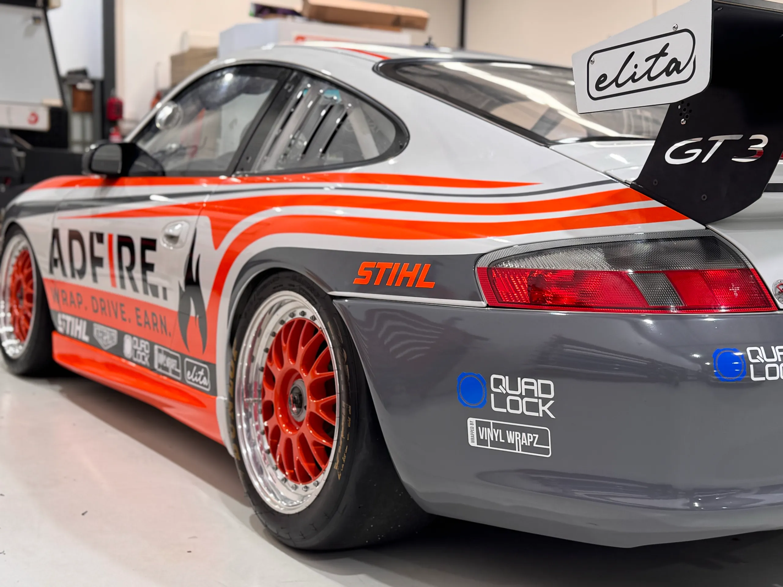Porsche GT3 rear quarter with Adfire graphics, orange wheels and a large rear wing