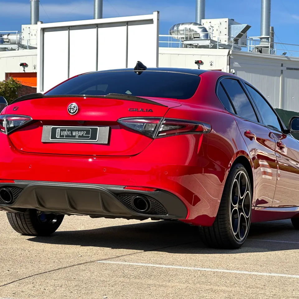 Gloss red Alfa Romeo Giulia viewed from the rear quarter outdoors