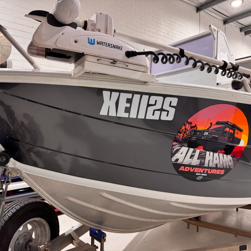 All Hamo Adventures circular logo on the charcoal-grey John Boy boat bow in the workshop