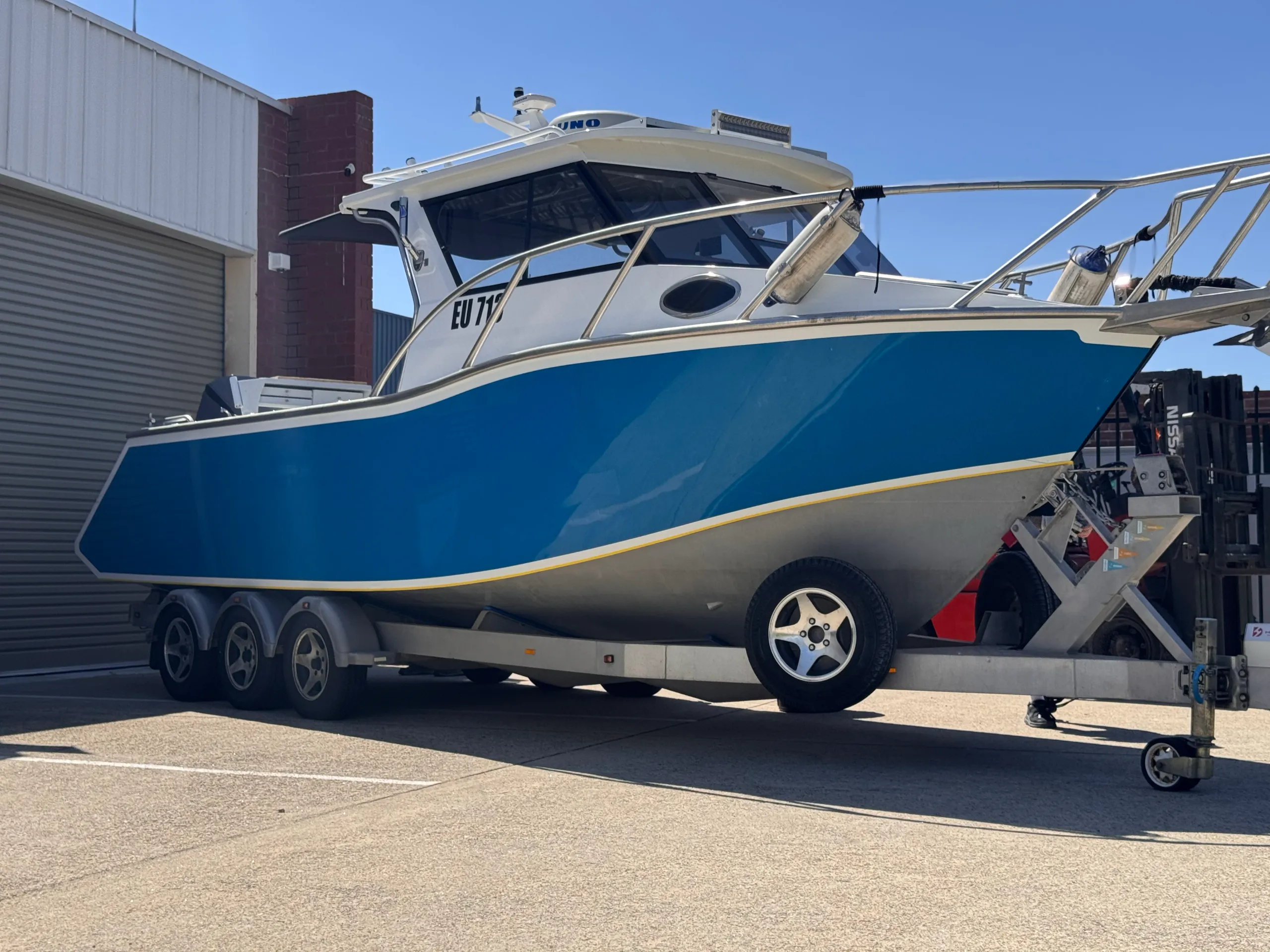 Blue Razerline Olympian on its trailer before the printed hull wrap was fitted