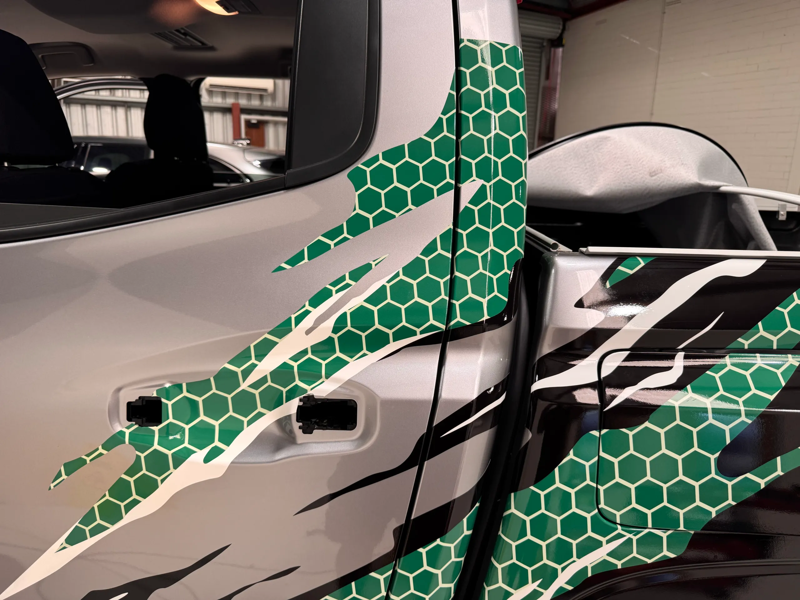 Green honeycomb and white claw graphics on the Triton doors with handles removed