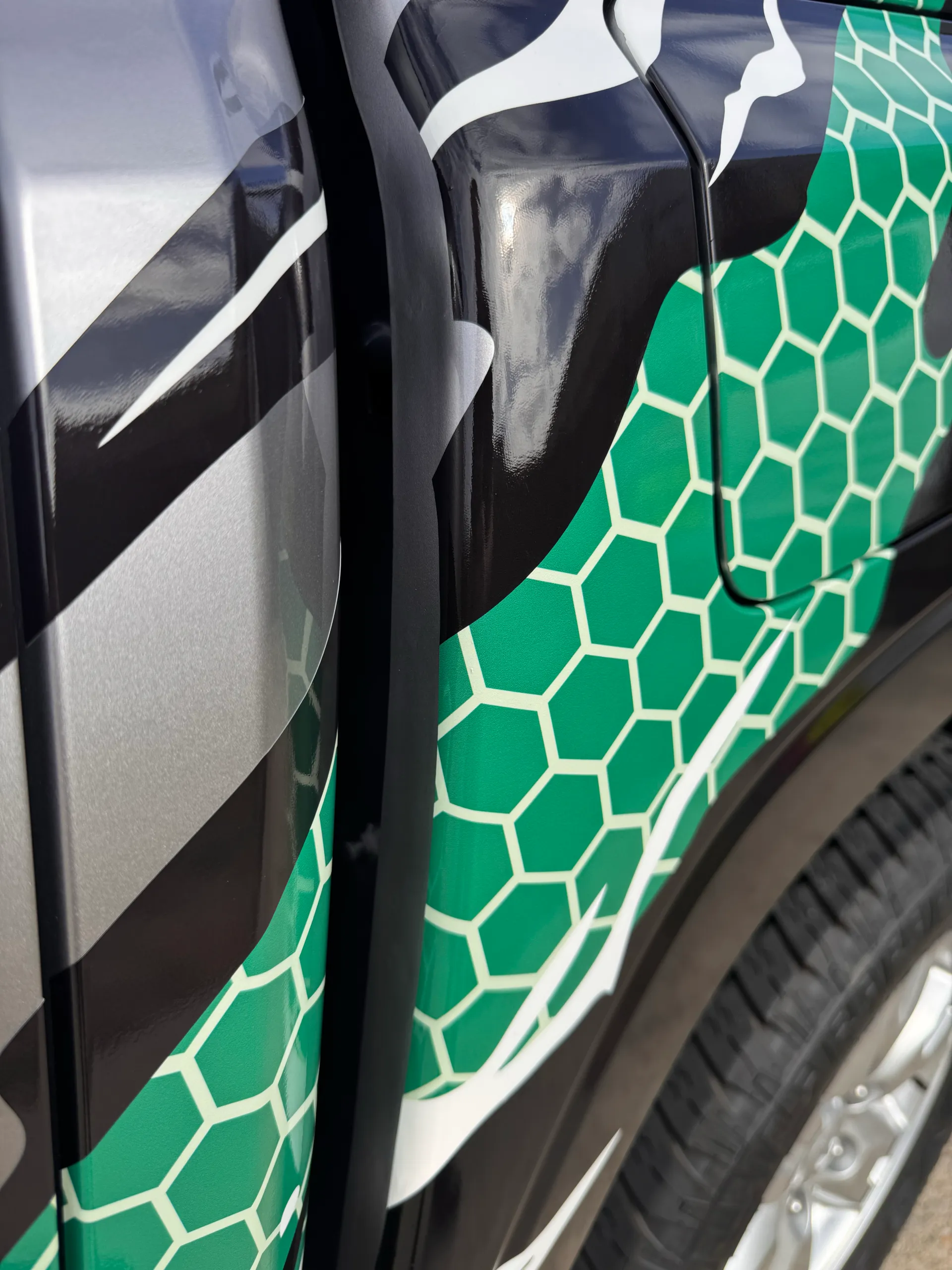 Green honeycomb and white claw artwork around the Triton fuel flap