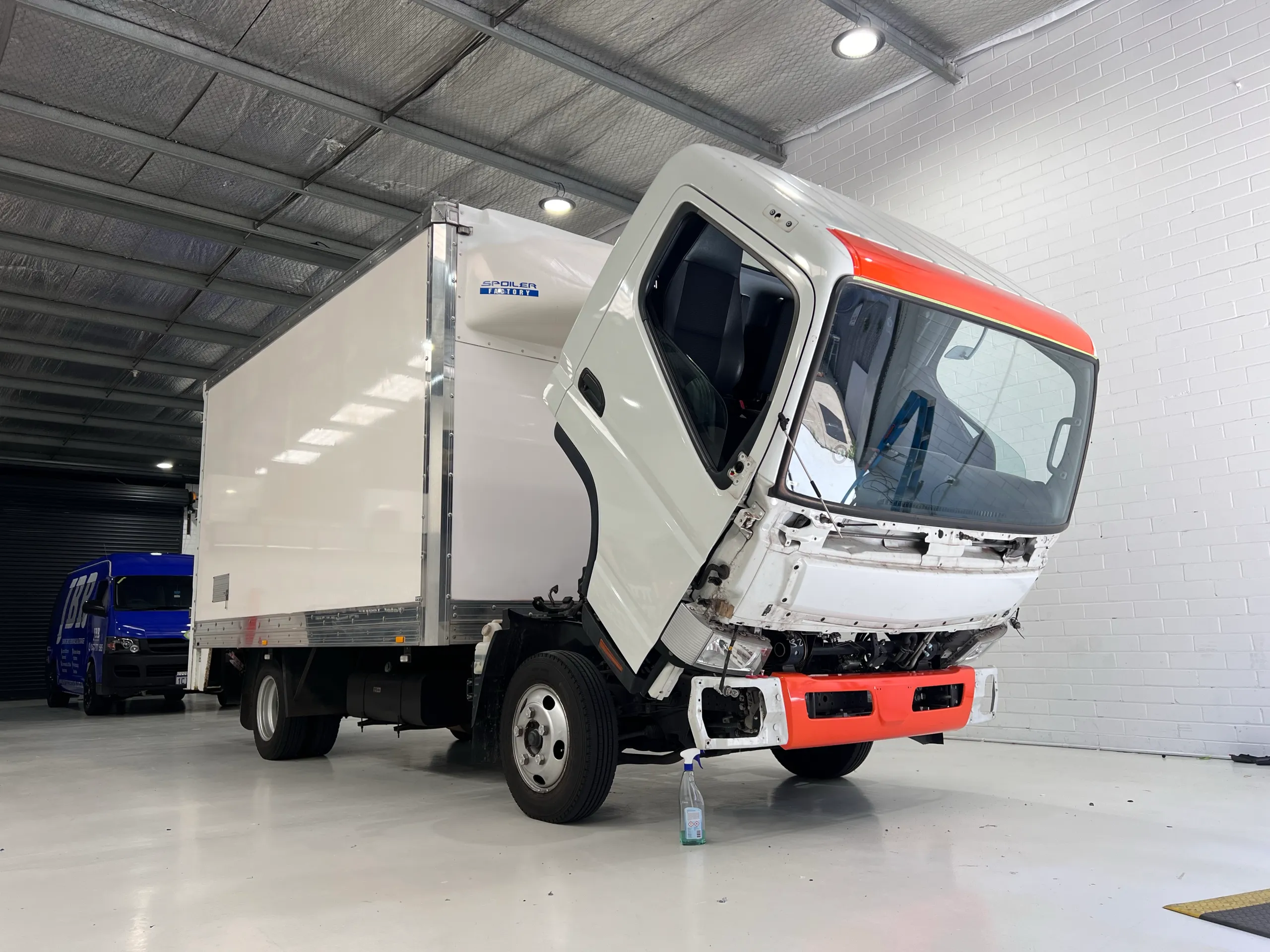 Truck with cab tilted forward during removal in the workshop