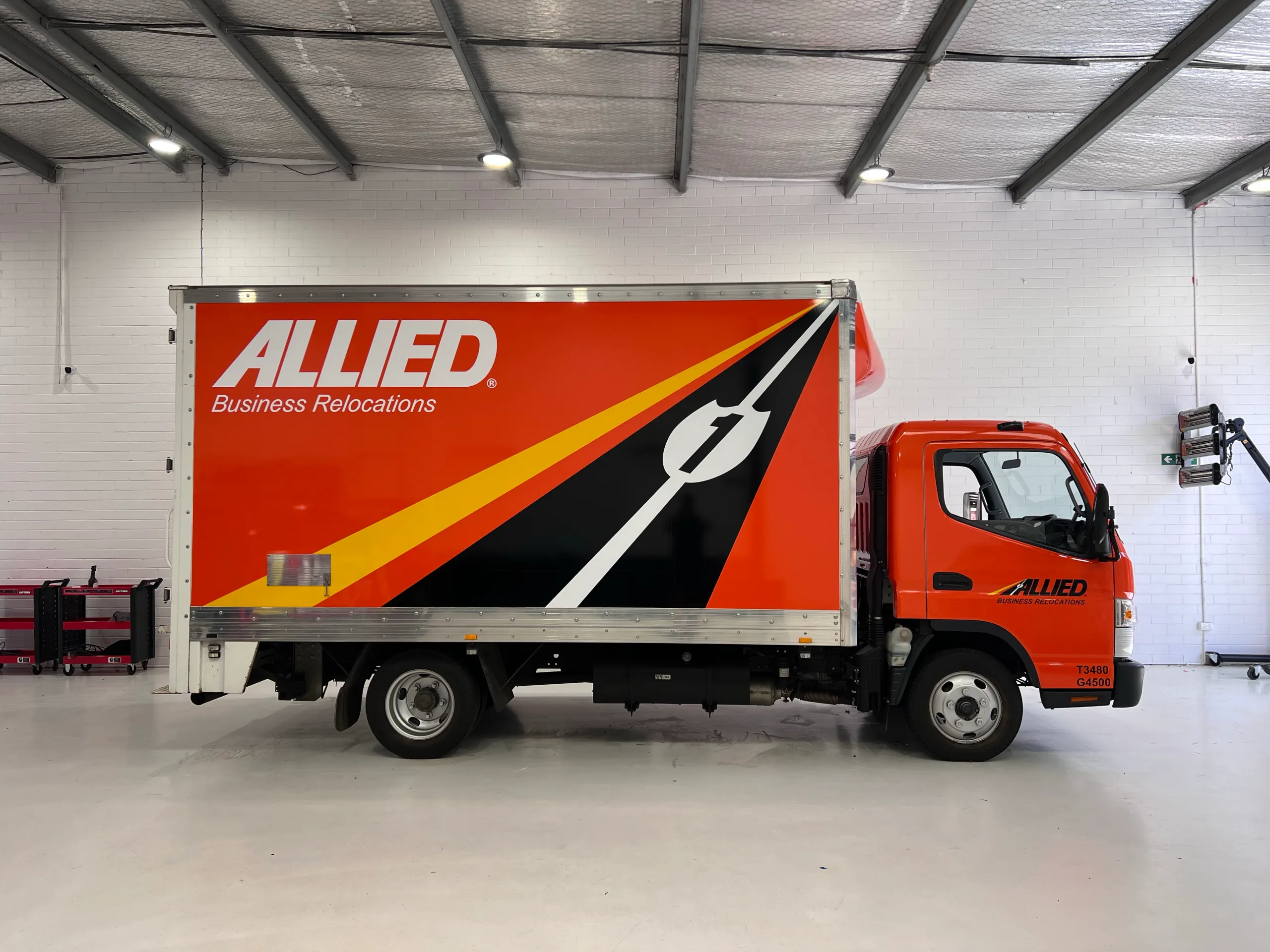 Orange and black Allied Movers graphics along the truck body