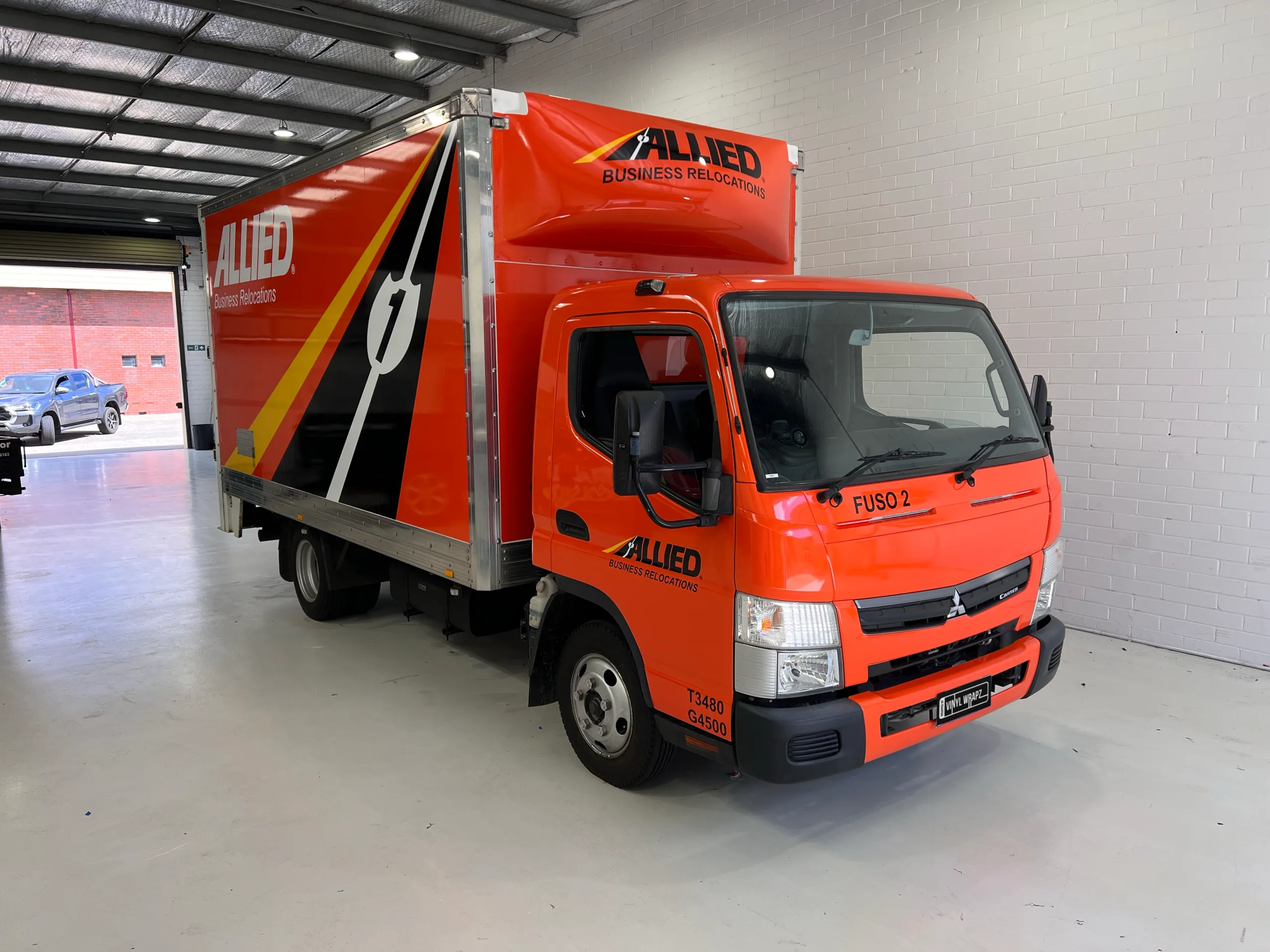 Wrapped Allied Movers truck at the workshop entrance