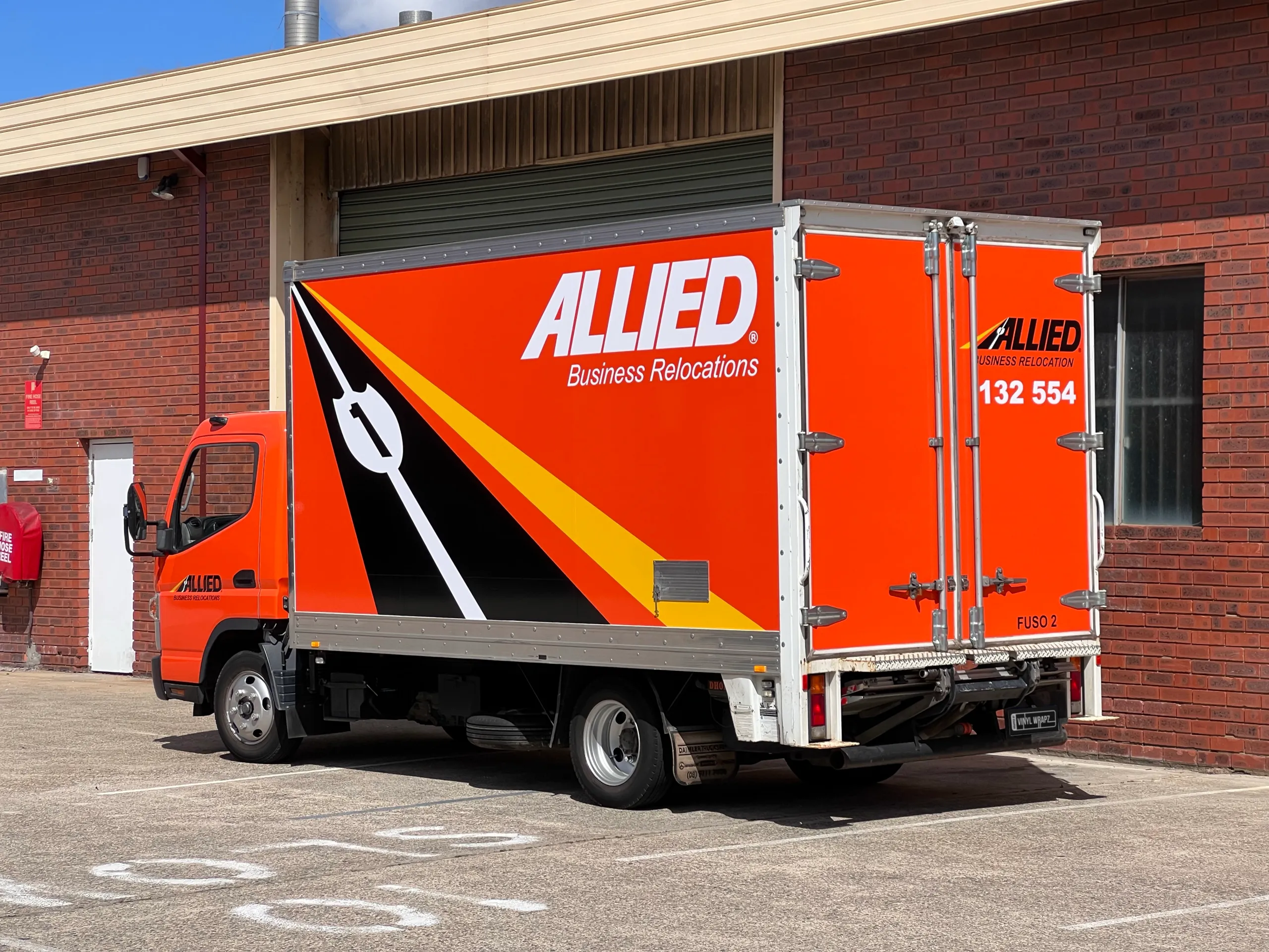 Wrapped truck parked outside showing its side and rear