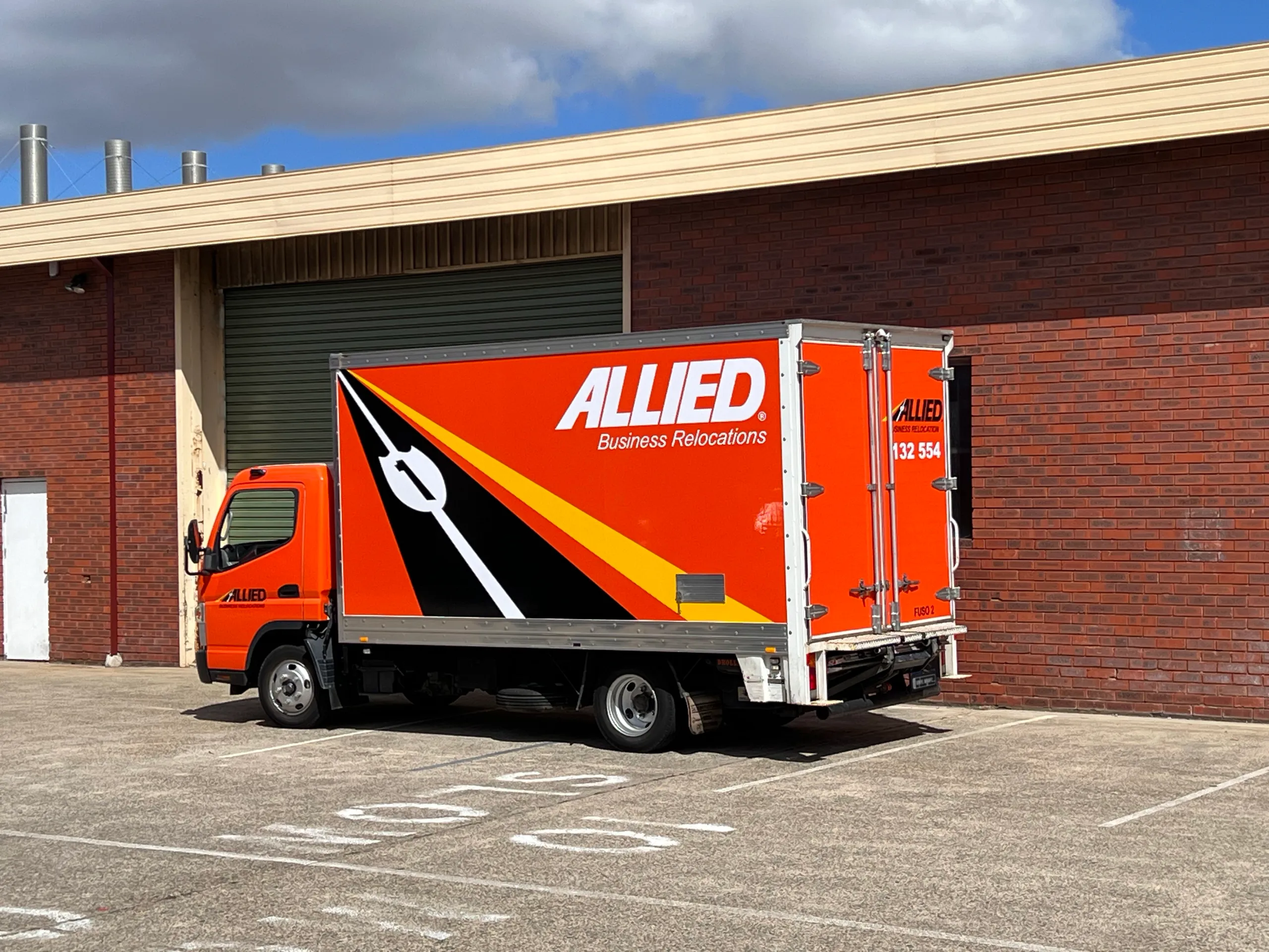 Orange and black truck graphics viewed from the rear quarter outdoors