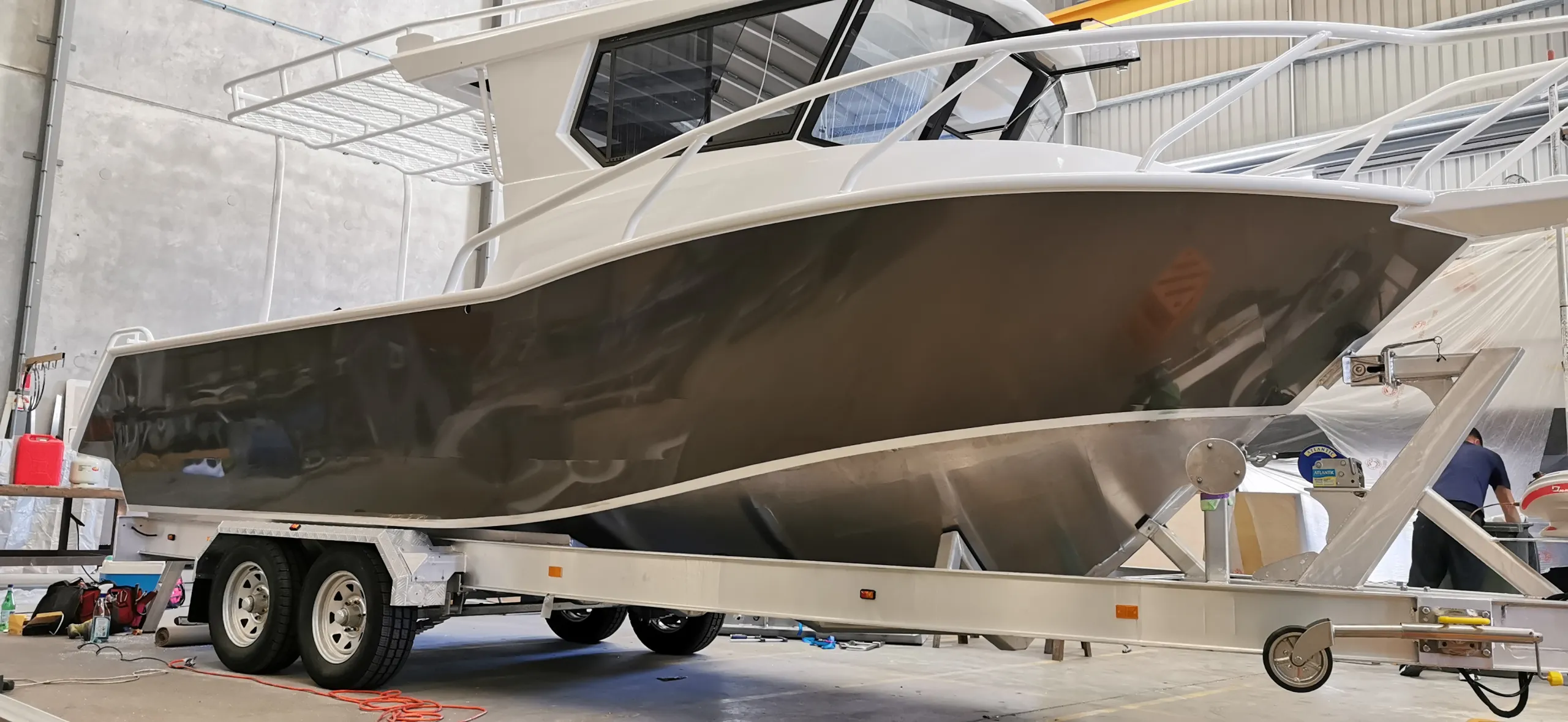 Charcoal film fitted along the boat hull, with an installer partly visible at the bow