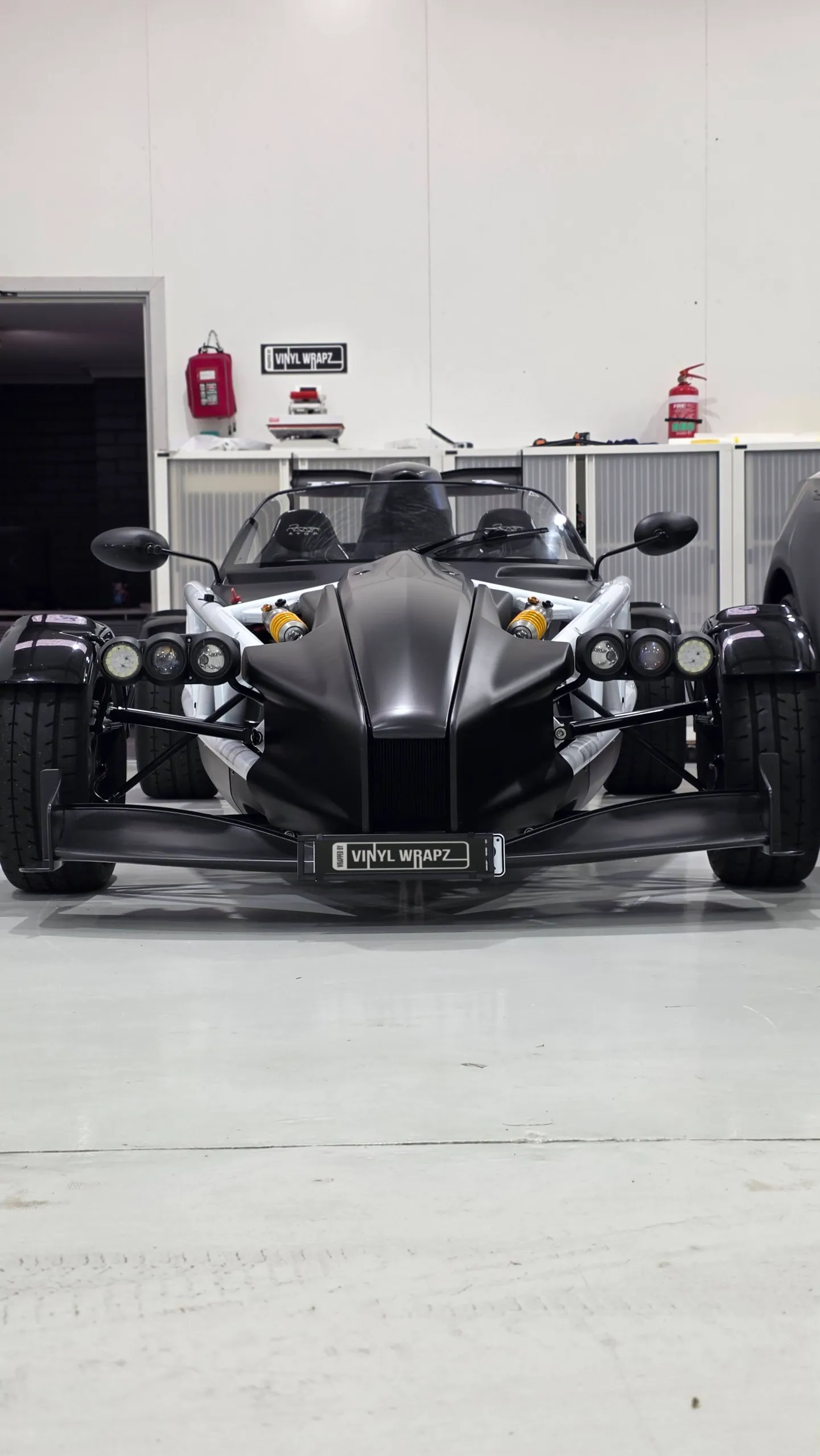 Front view of the black Ariel Atom with exposed wheels and paired headlights
