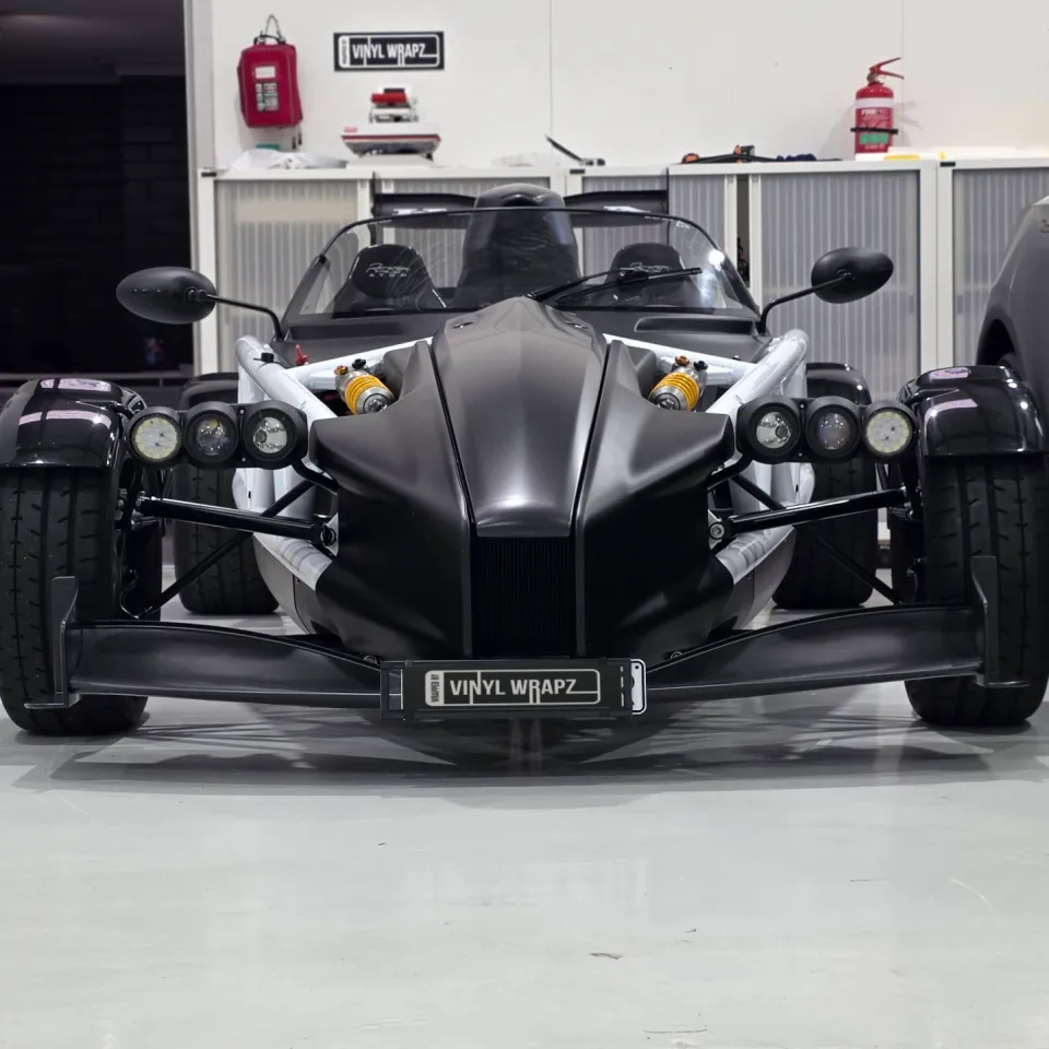 Front view of the black Ariel Atom with exposed wheels and paired headlights
