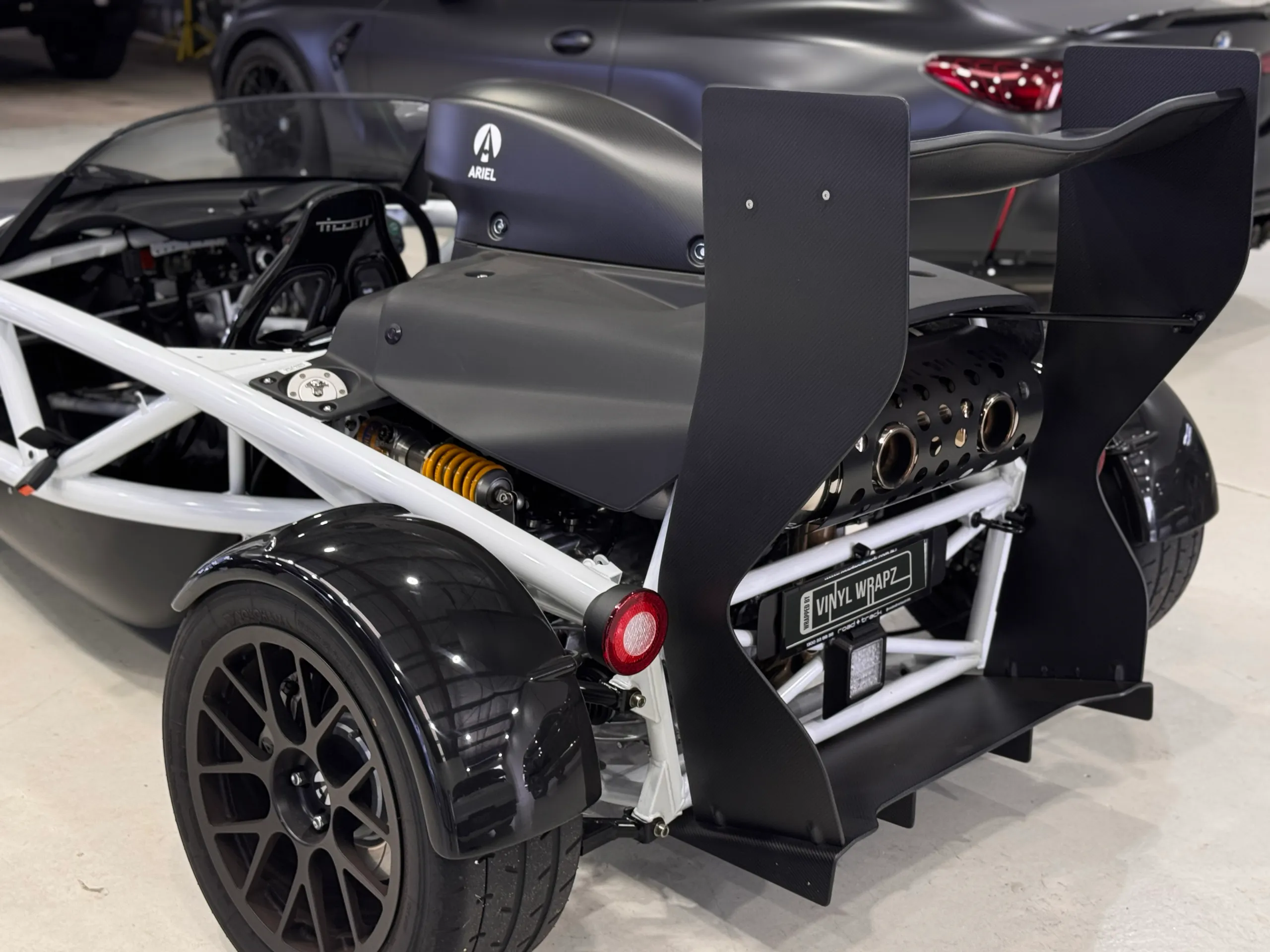 Ariel Atom rear quarter with its wing, engine cover and exposed white frame