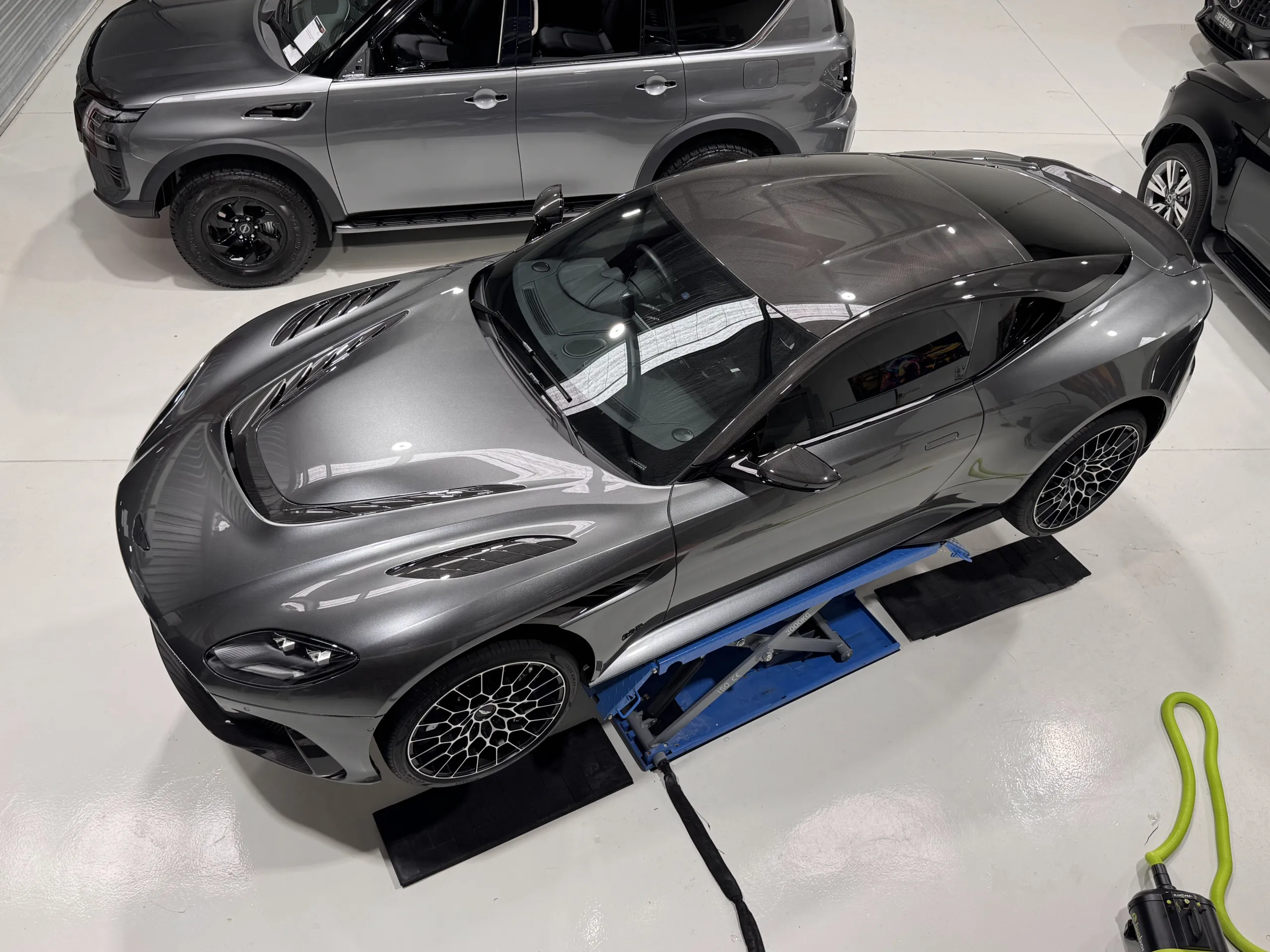 Overhead view of the grey Aston Martin DBS on a workshop lift