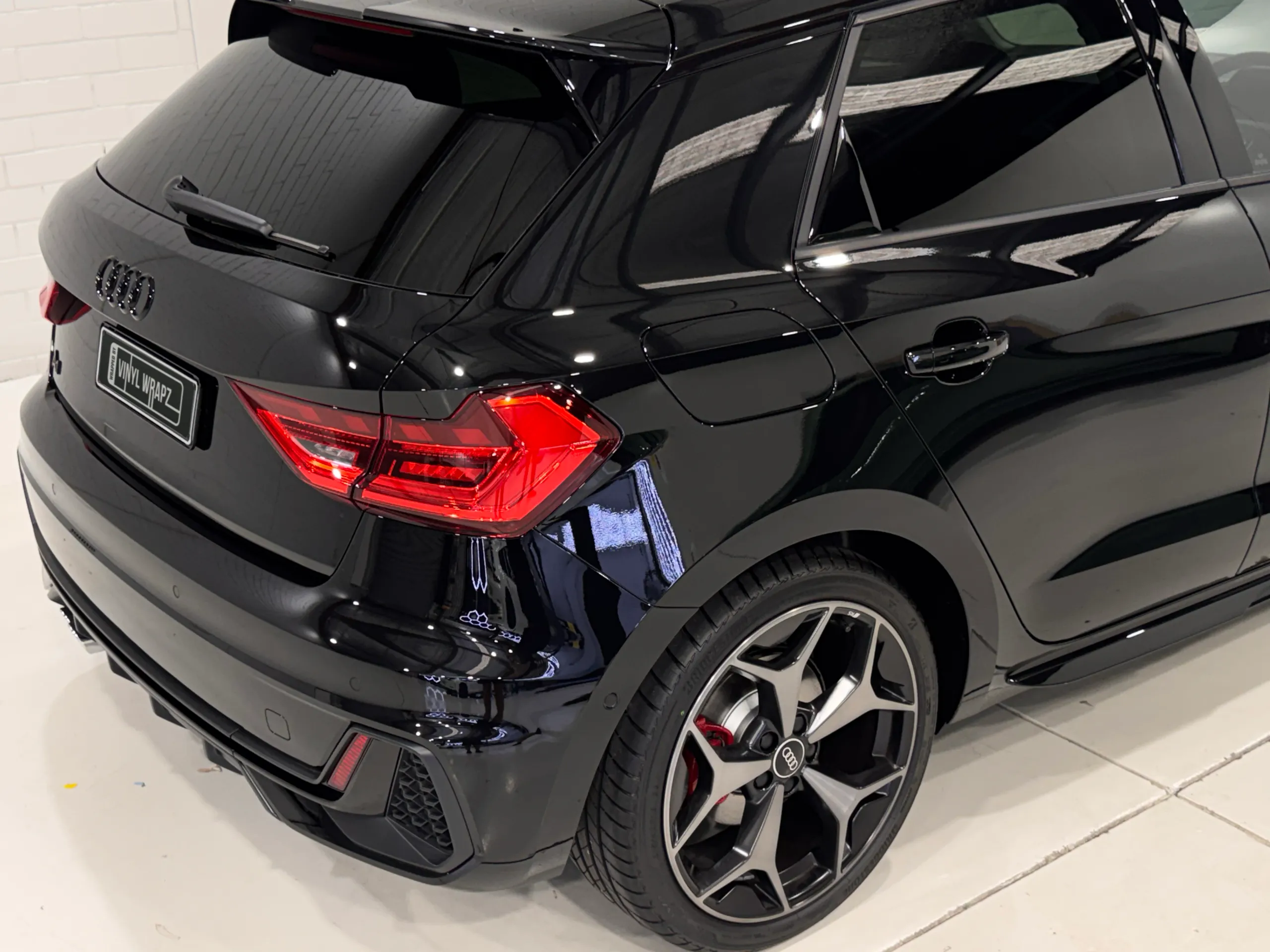 Gloss black Audi A1 rear quarter, tail light and rear wheel in the workshop