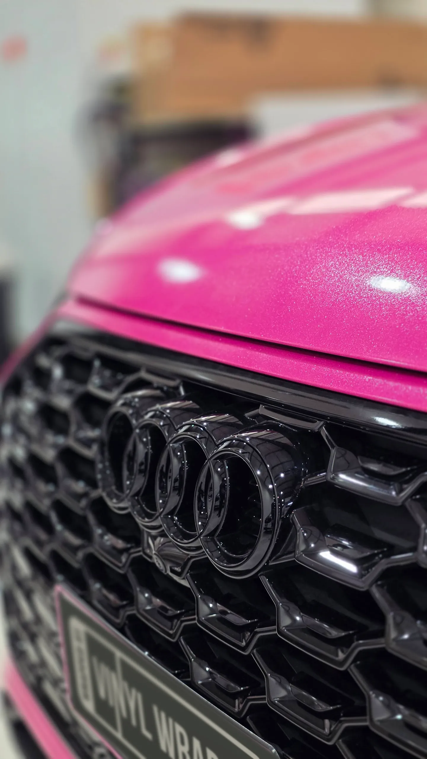Black Audi rings on the grille beneath the sparkling pink bonnet
