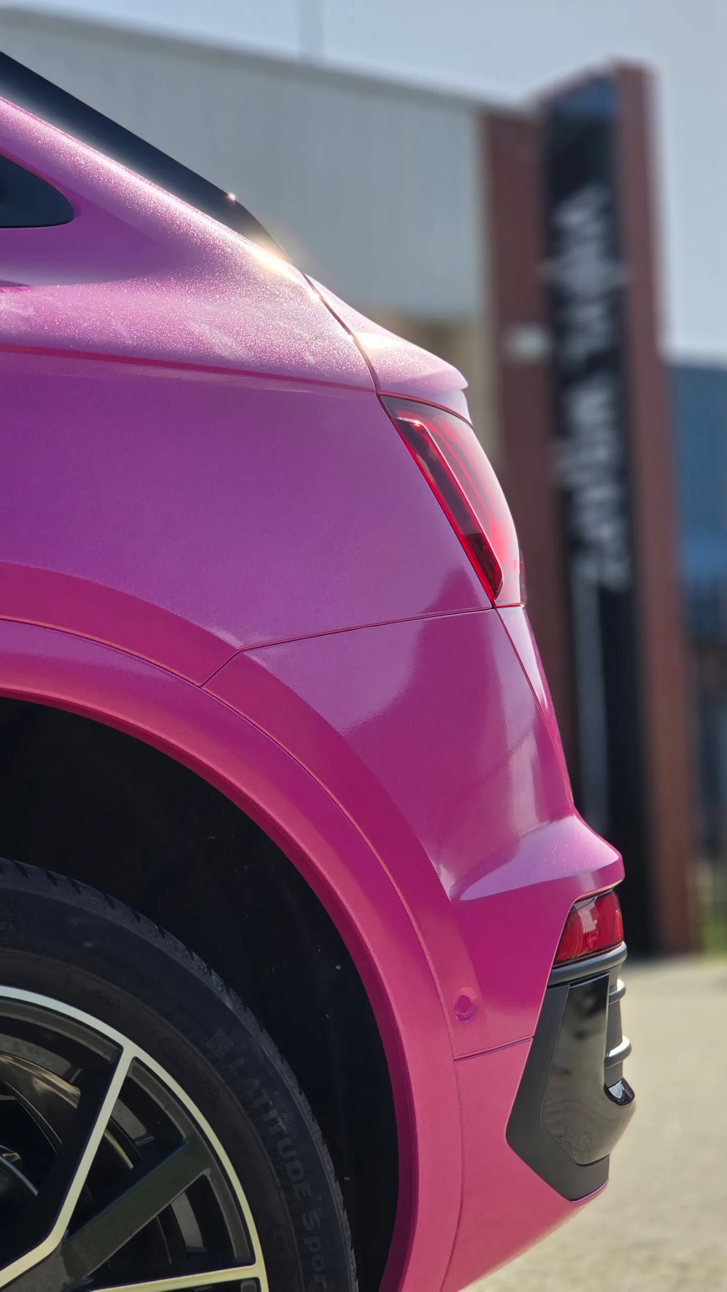 Detail of the pink Audi Q5 Sportback rear wheel arch and bumper in sunlight