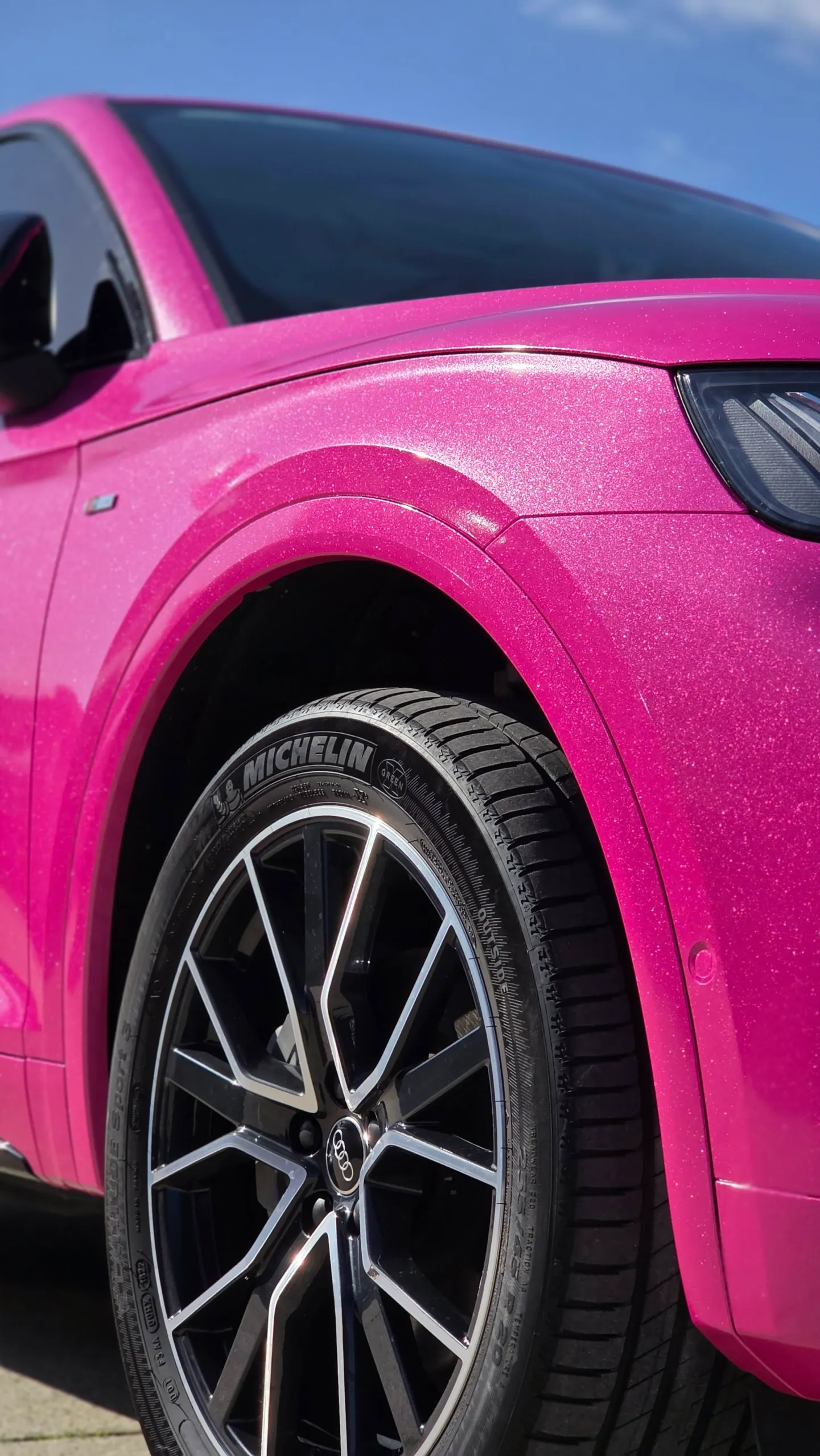 Low-angle detail of the pink Audi Q5 Sportback front wheel and sparkling guard
