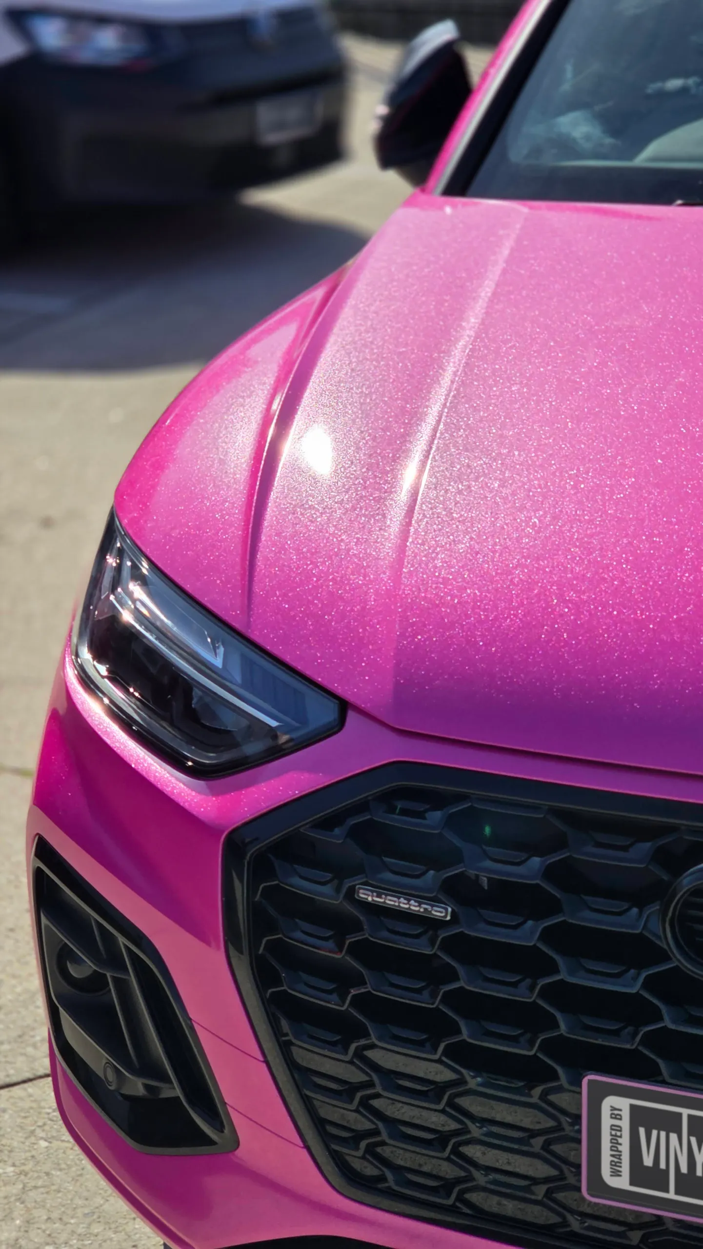 Elevated detail of the sparkling pink Audi bonnet, headlight and black grille