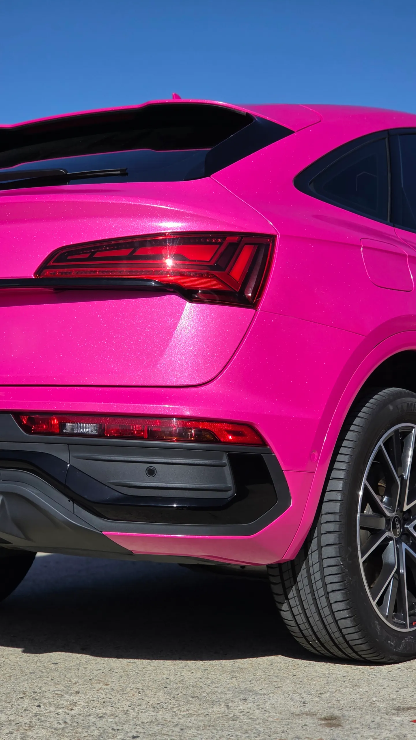 Pink Audi Q5 Sportback rear quarter and tail light in bright sunlight