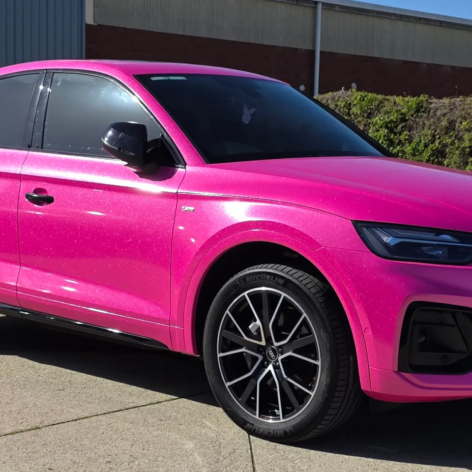 Sparkling pink Audi Q5 Sportback viewed from the front quarter outside the workshop