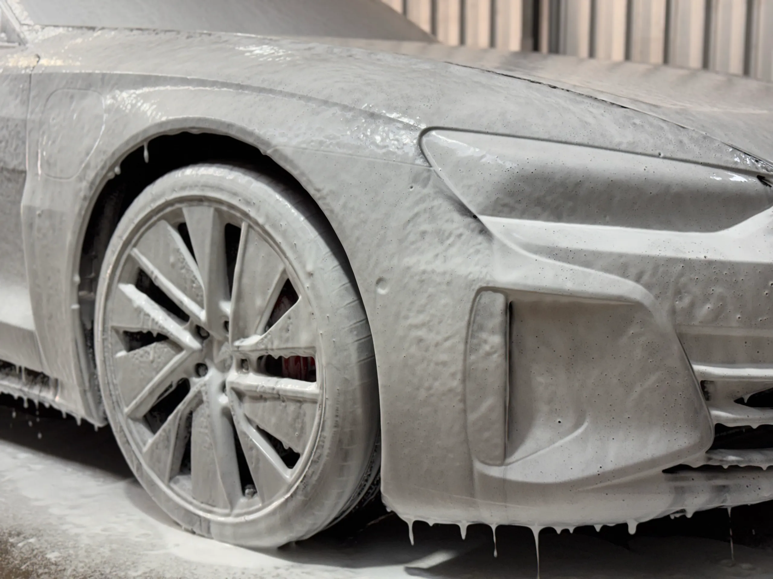 Audi RS e-tron GT front wheel and bodywork covered in white washing foam