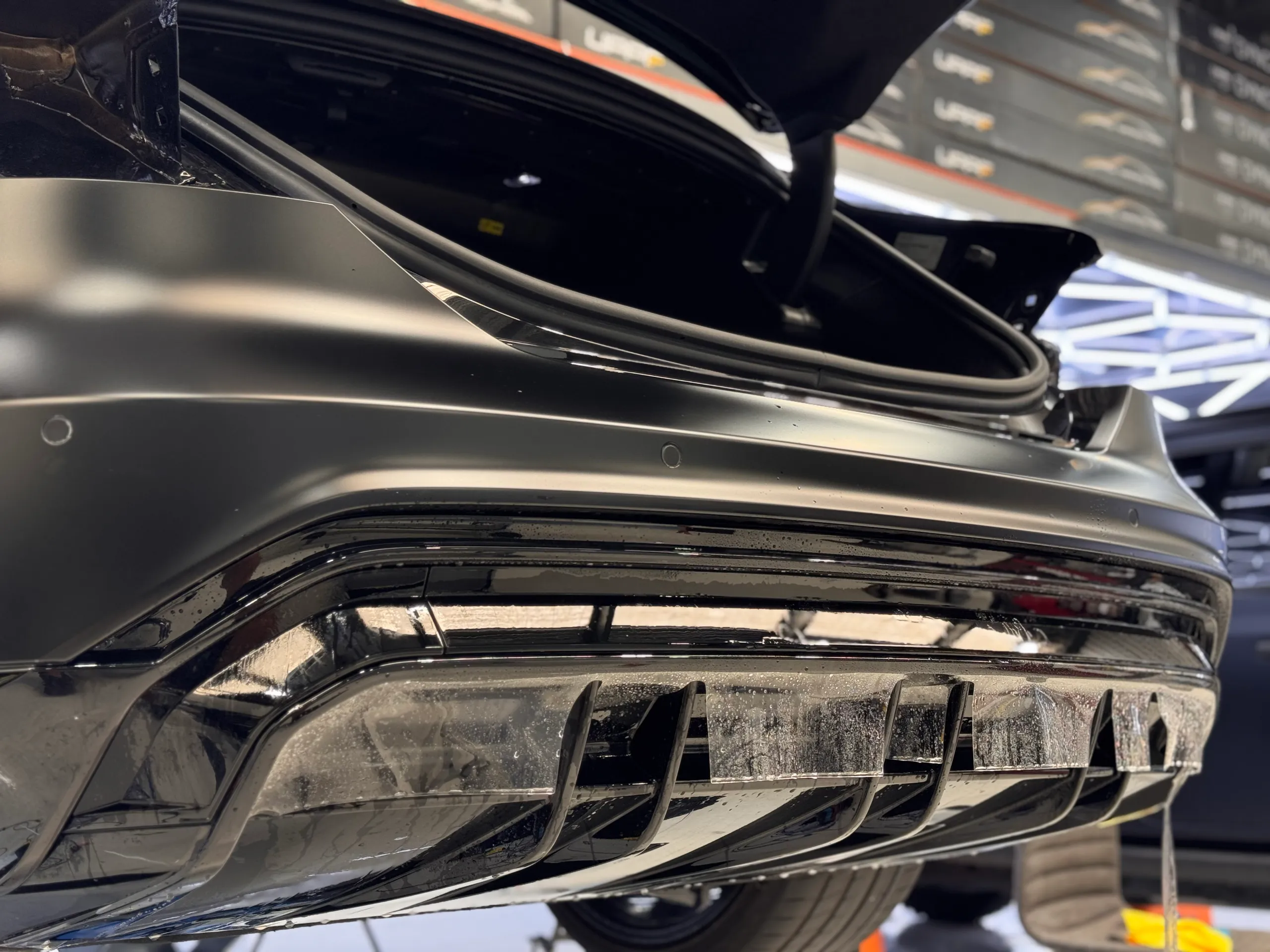 Audi RS e-tron GT rear bumper and diffuser on a workshop lift with the boot open