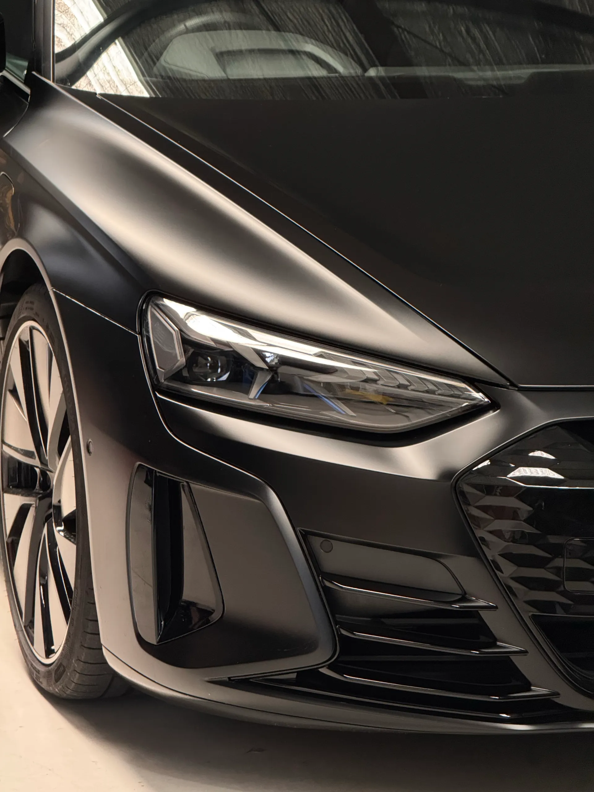 Matte black Audi RS e-tron GT headlight and front bumper in the workshop