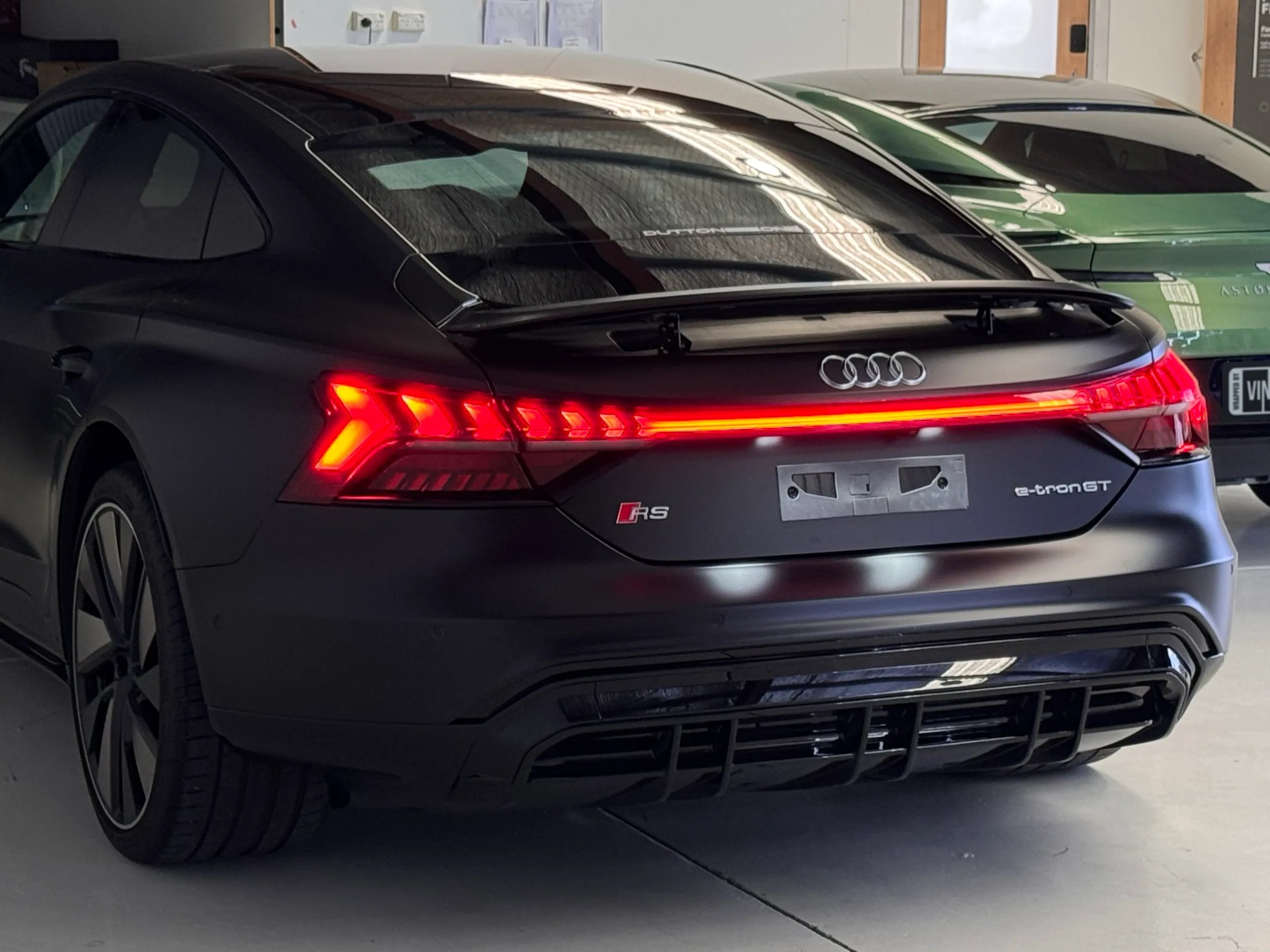 Rear-quarter view of a matte black Audi RS e-tron GT in the workshop