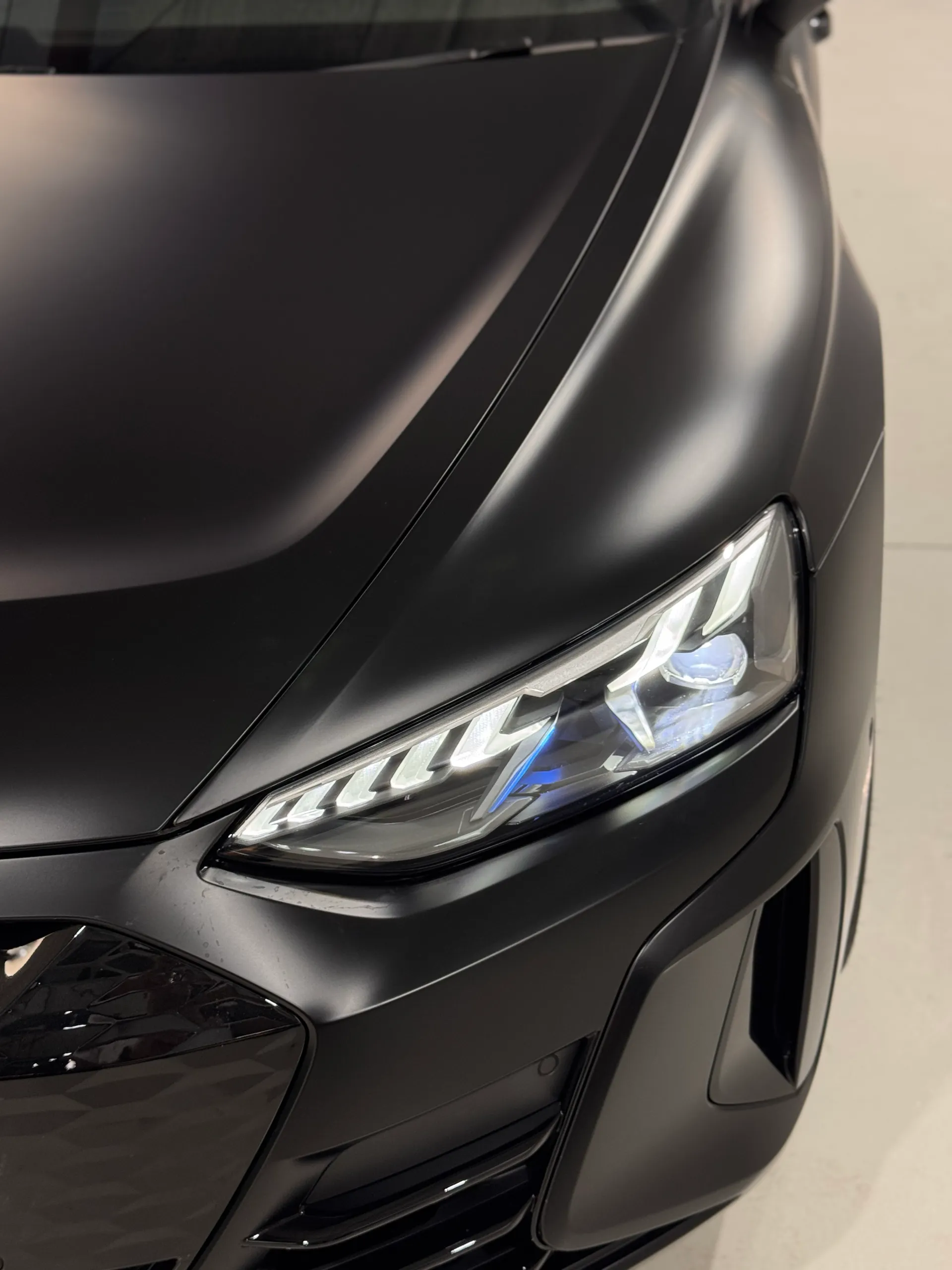 Elevated view of the matte black Audi RS e-tron GT bonnet and front headlight