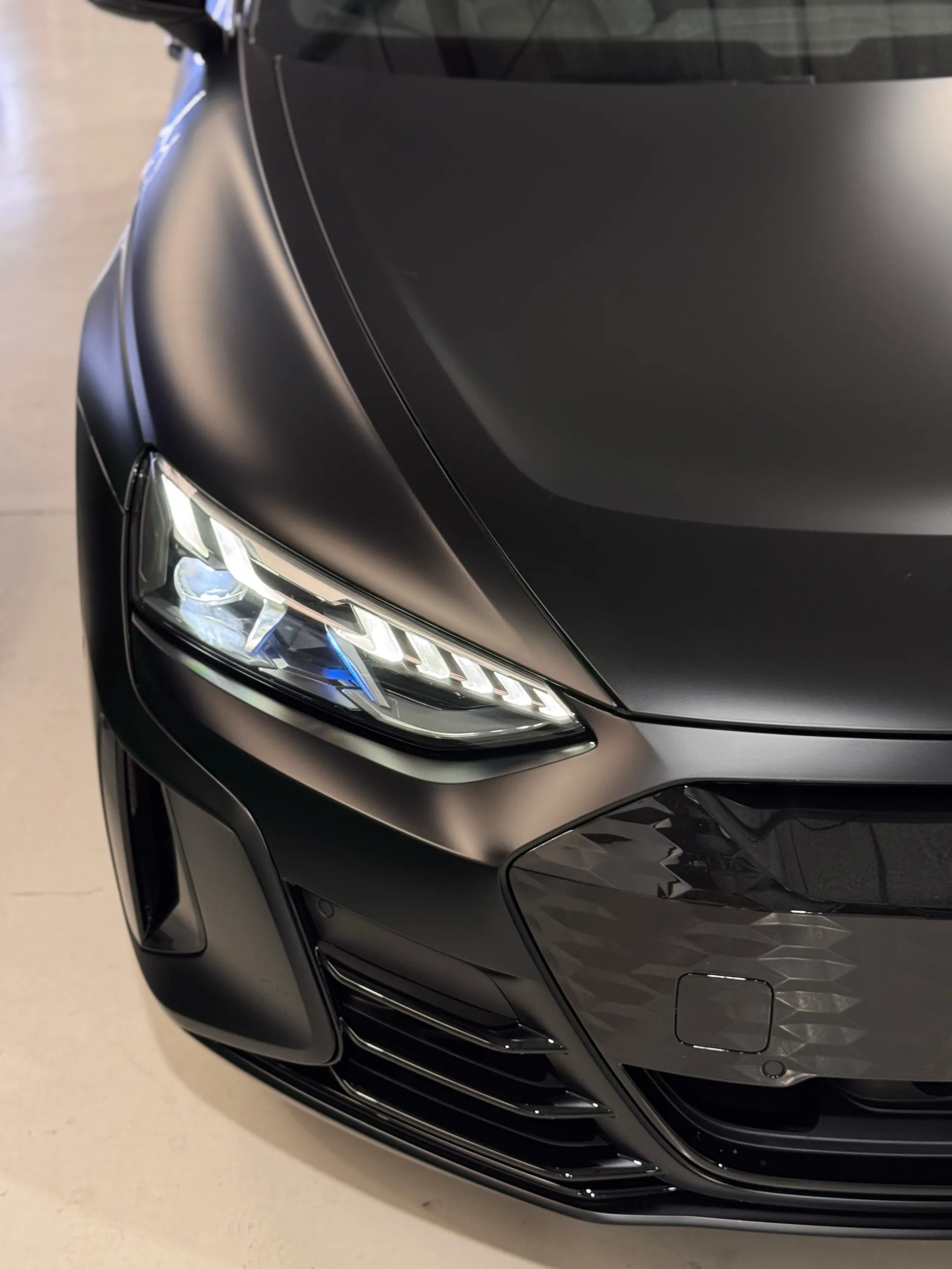 Matte black Audi RS e-tron GT headlight and grille viewed from above