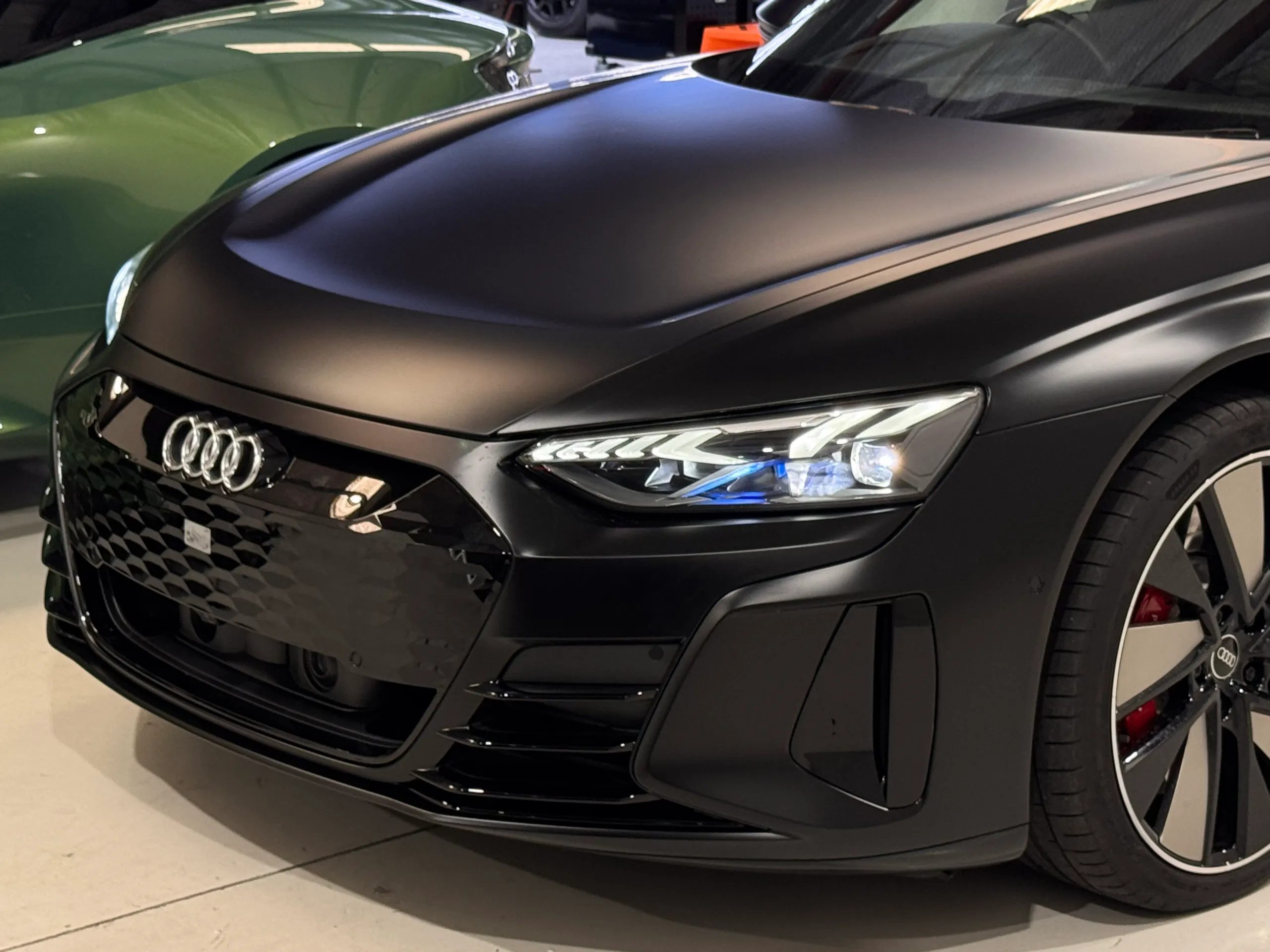 Matte black Audi RS e-tron GT bonnet, headlight and front wheel in the workshop