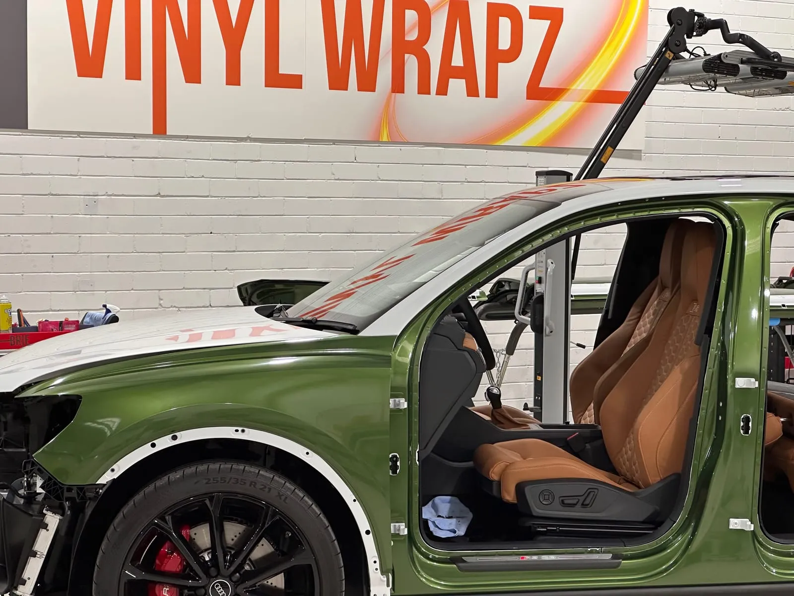Green Audi RS mid colour change wrap under the overhead film arm in the Vinyl Wrapz workshop