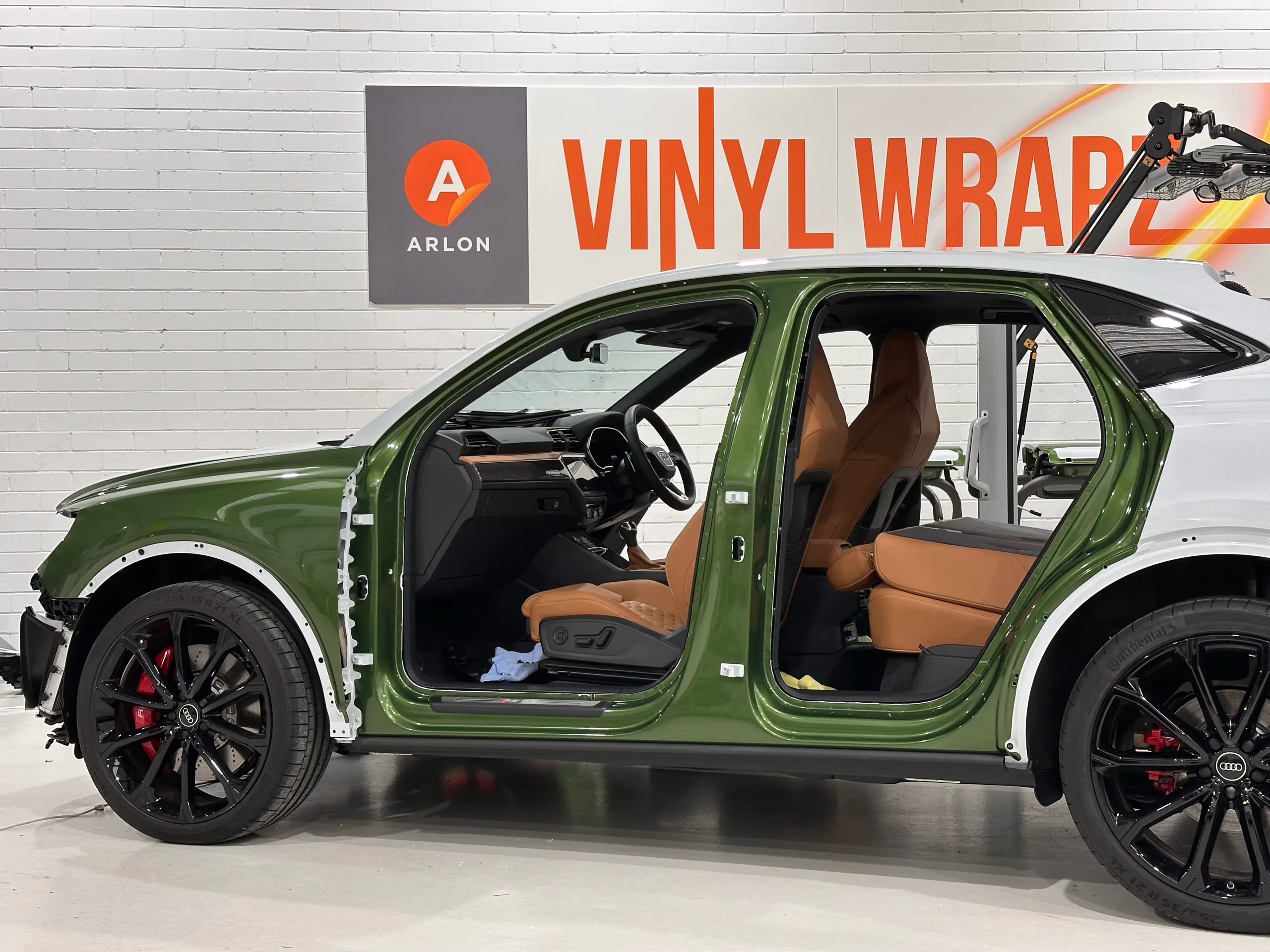 Audi RS Q3 Sportback side during wrapping, showing green door openings and the original white rear quarter