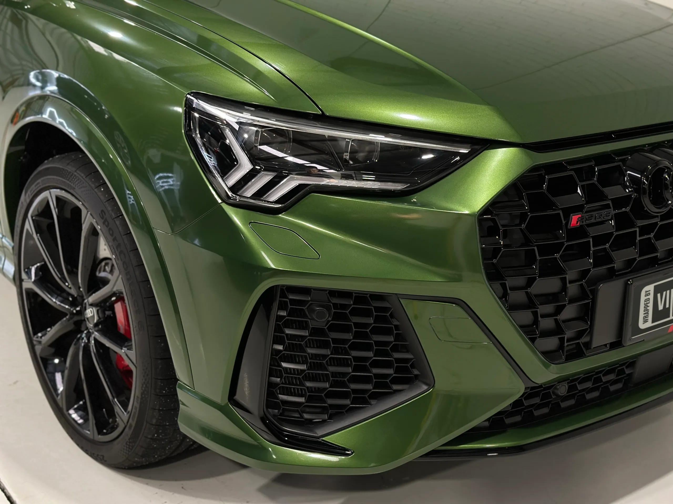 Metallic green Audi RS Q3 Sportback wrap around the front guard and headlight