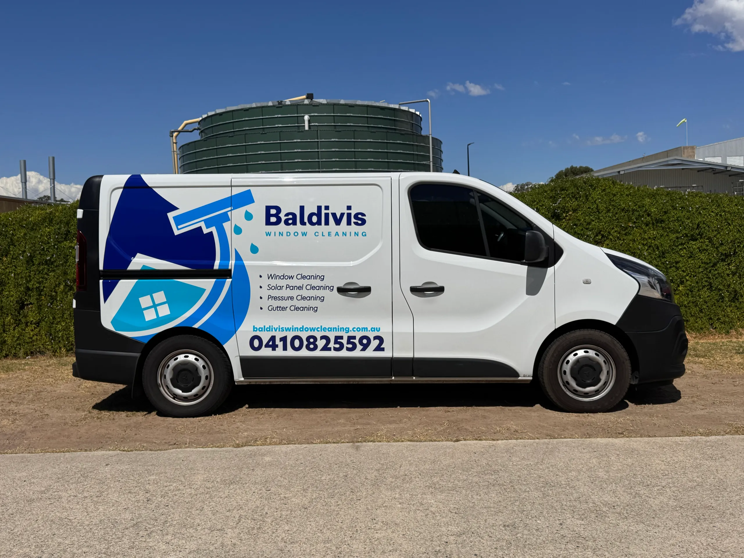 Side view of a white Mitsubishi Express with blue Baldivis Window Cleaning graphics outdoors