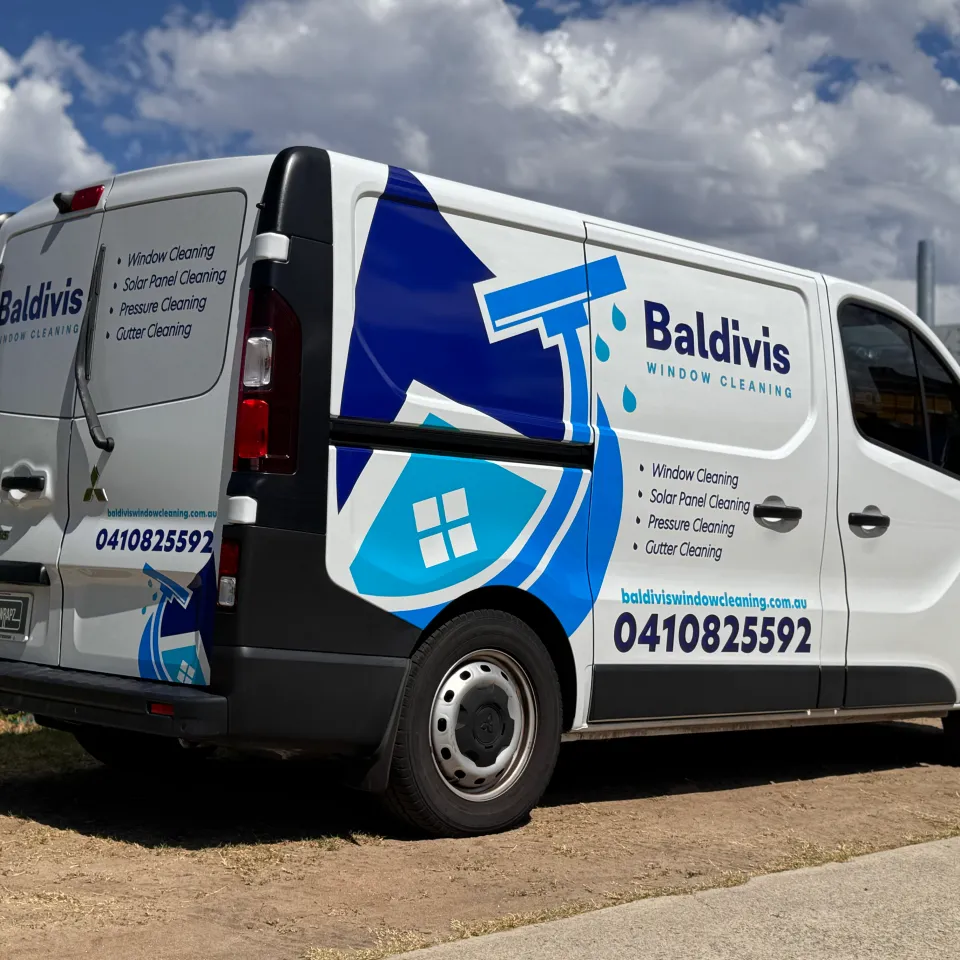 Rear-quarter view of the Baldivis Window Cleaning van showing branding across the side and rear doors