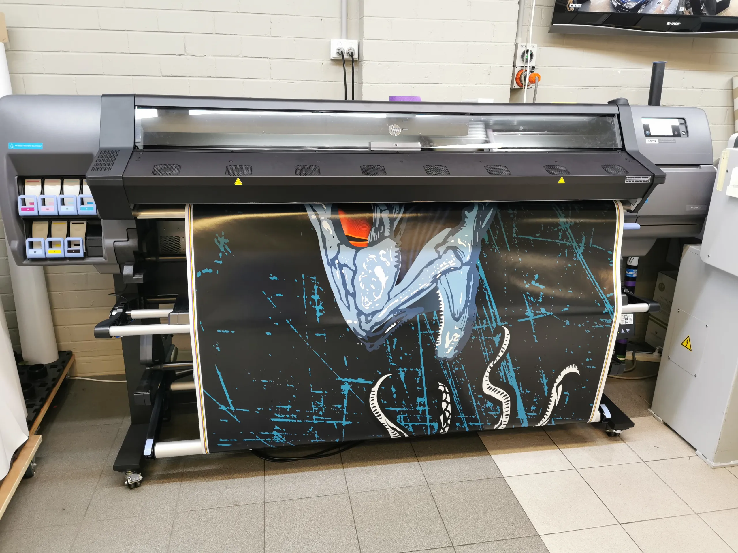Blue fish artwork with a red eye being printed for a boat hull wrap