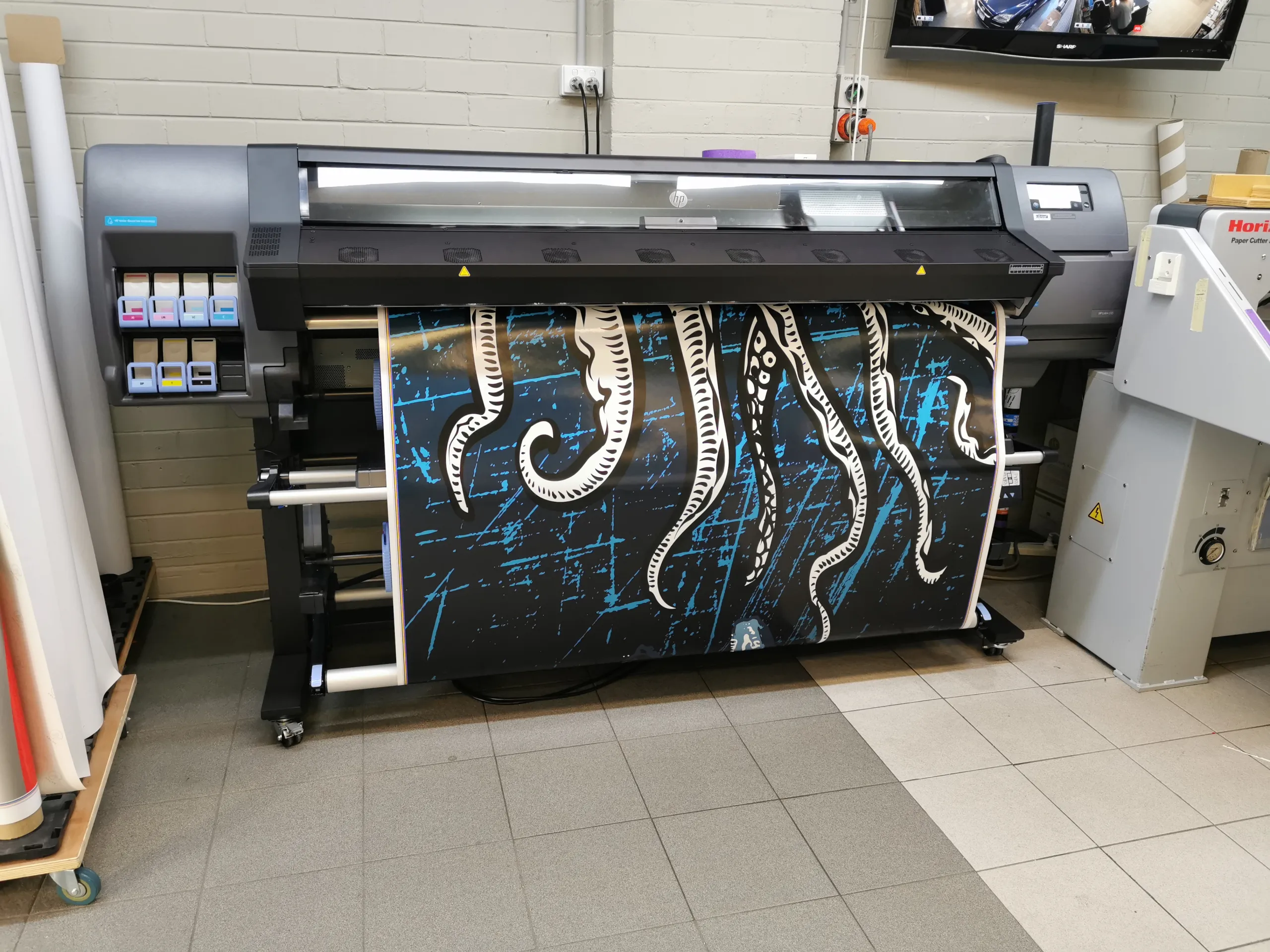 White squid tentacles on a black and blue background being printed for a boat wrap