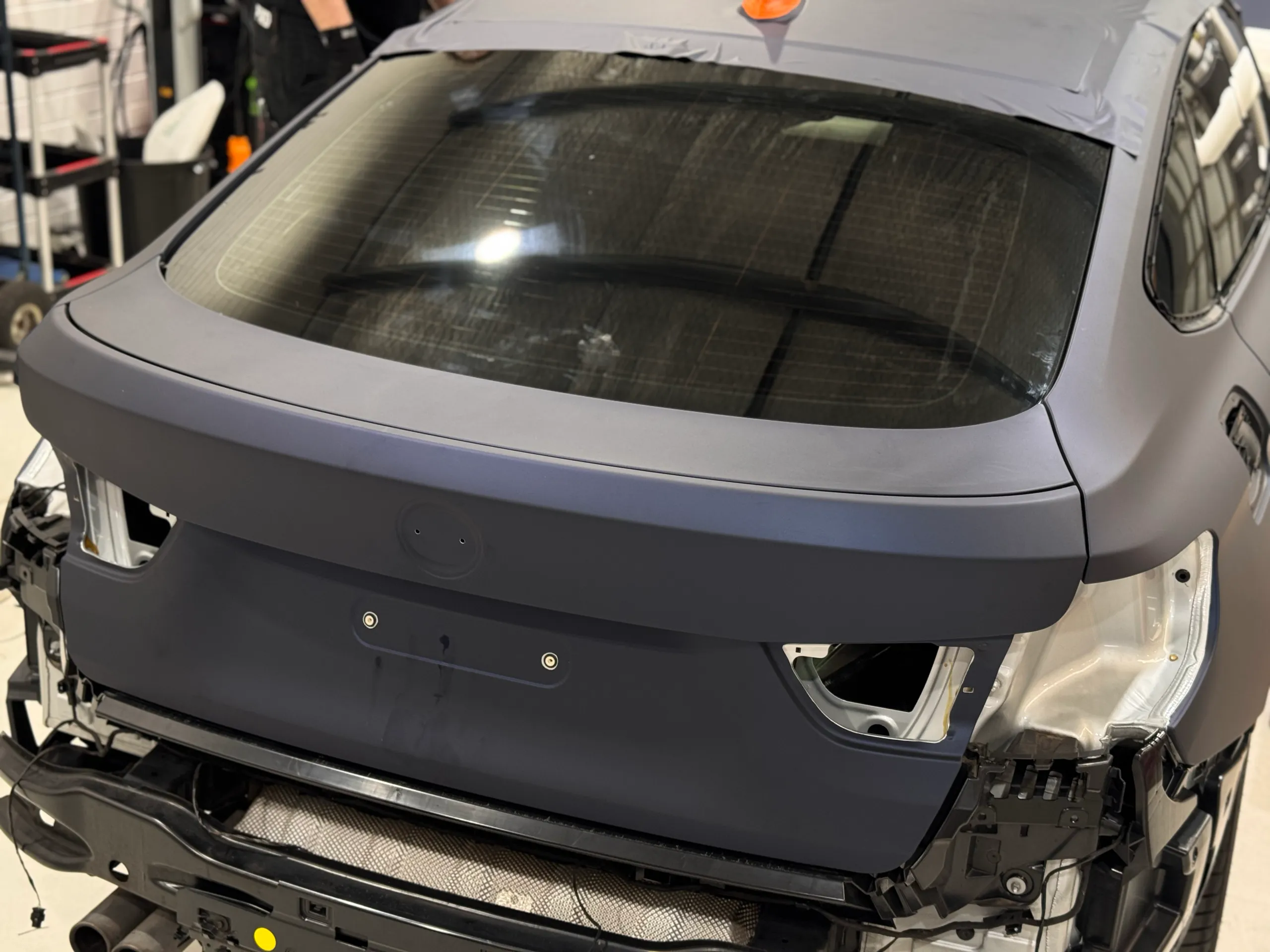 Satin blue-grey BMW Gran Turismo tailgate during wrapping with rear lights and bumper removed
