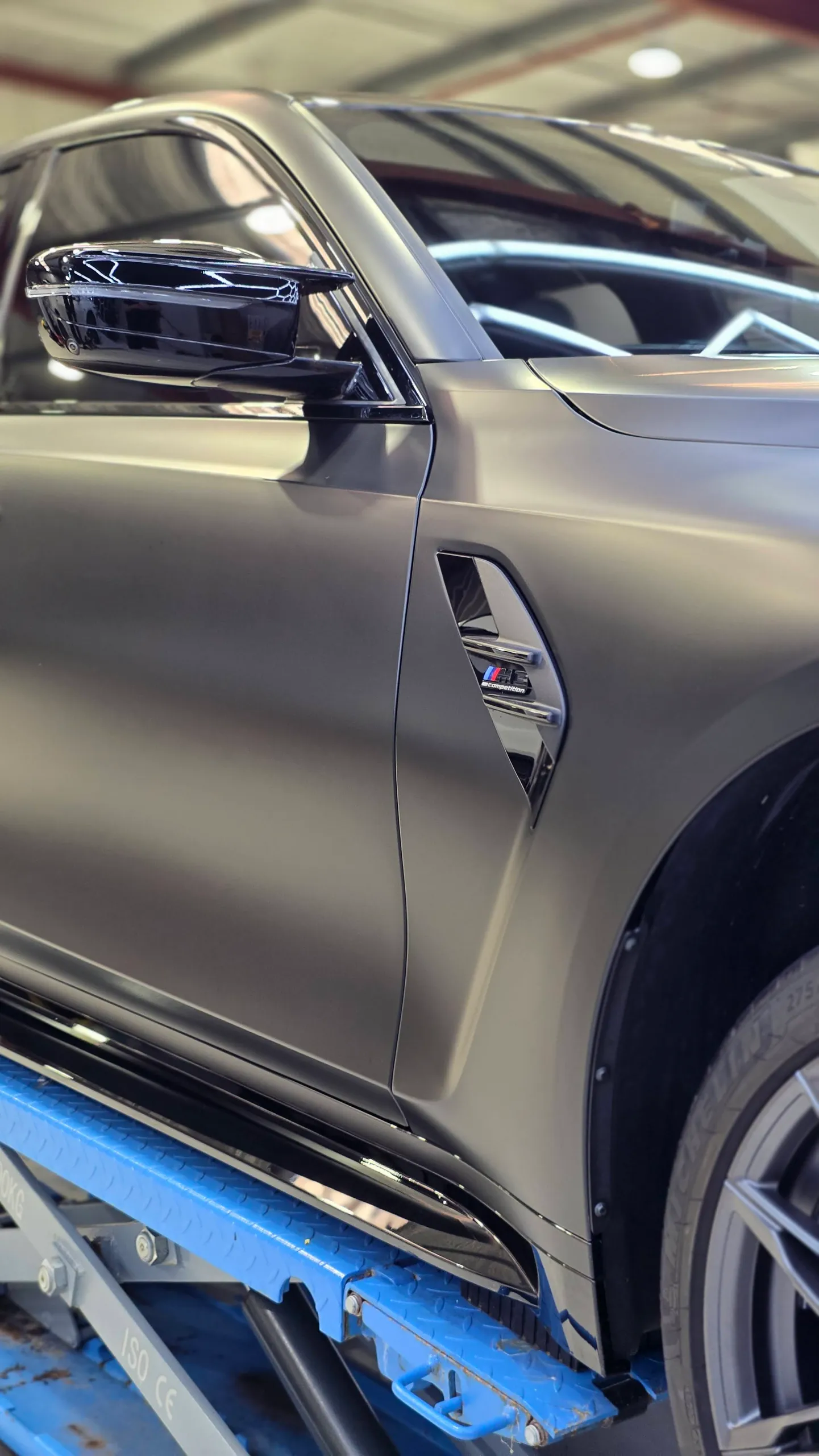 Gloss black mirror cap beside the satin grey BMW M3 Competition door and front guard