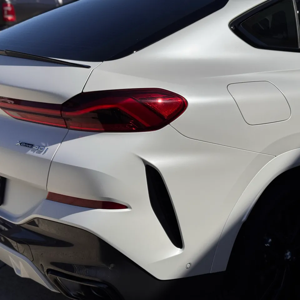 Satin white BMW X6 tailgate and rear quarter in sunlight