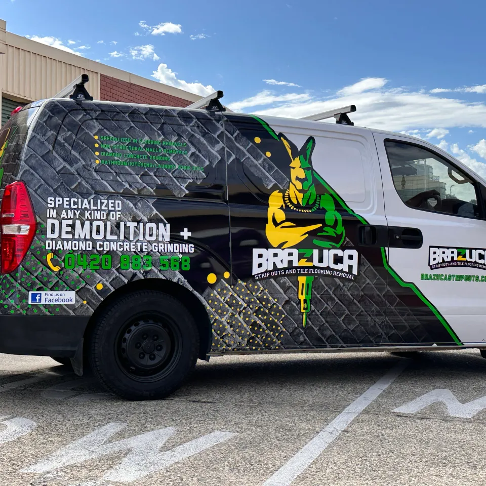 Brazuca Hyundai iLoad with black brick graphics and a green and yellow kangaroo design outdoors