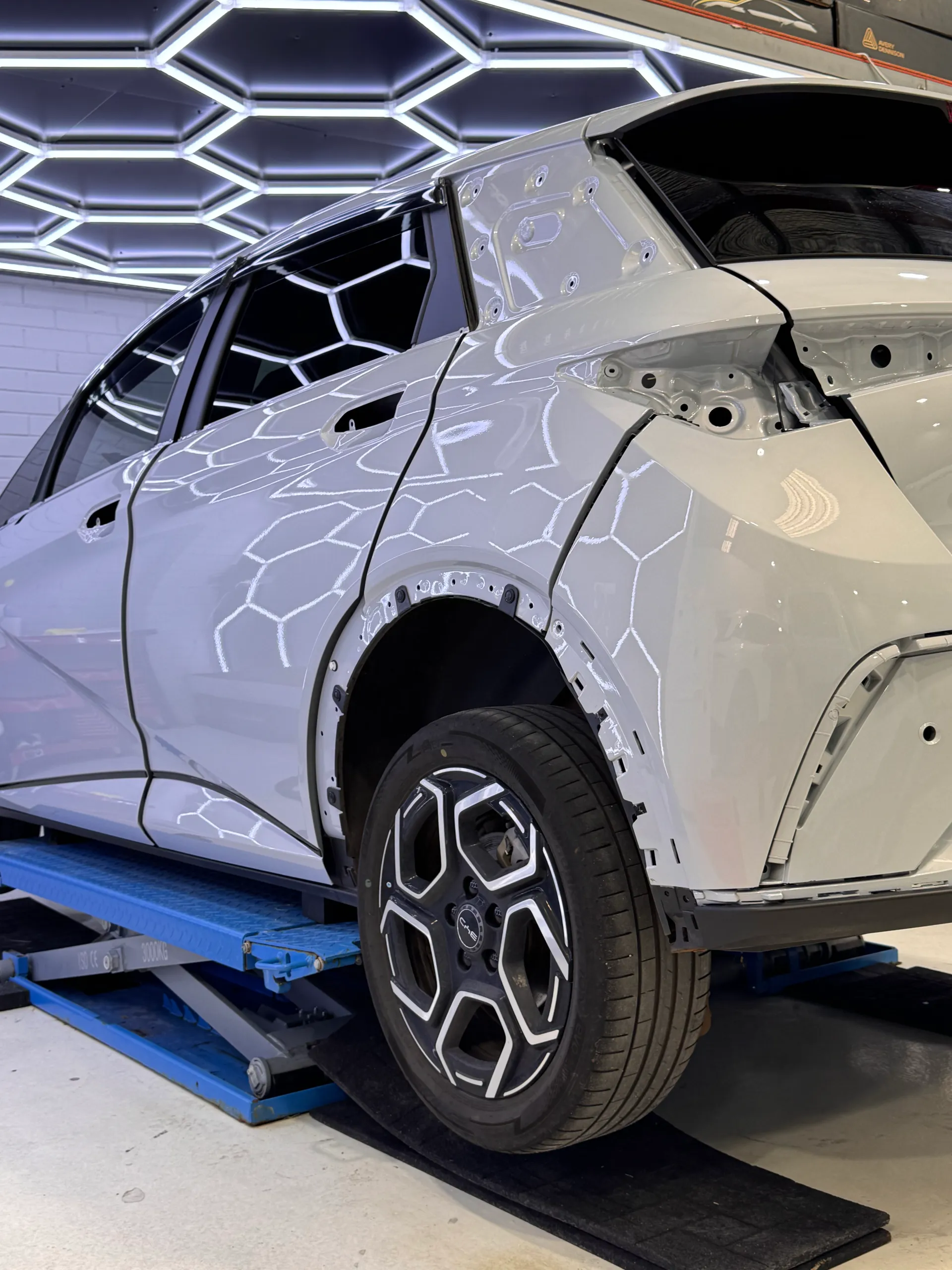 White BYD Atto 3 rear quarter with lights and trim removed before the purple colour change