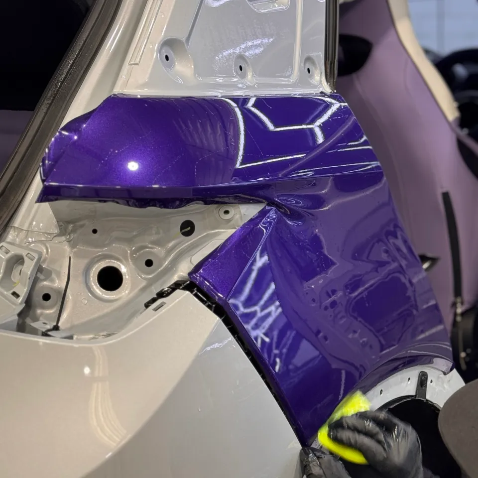Gloved hands fitting purple film around the BYD Atto 3 rear-light opening