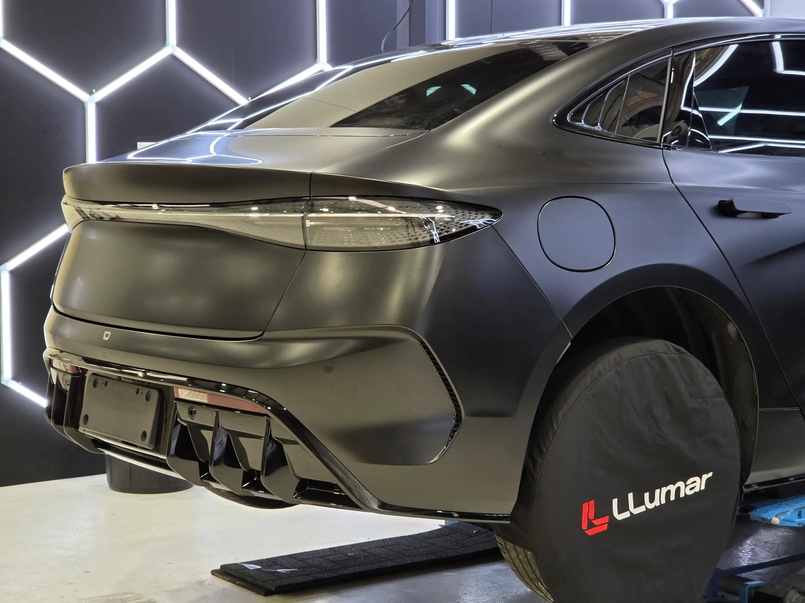 Satin black BYD Seal rear quarter and boot during installation, with a protective wheel cover