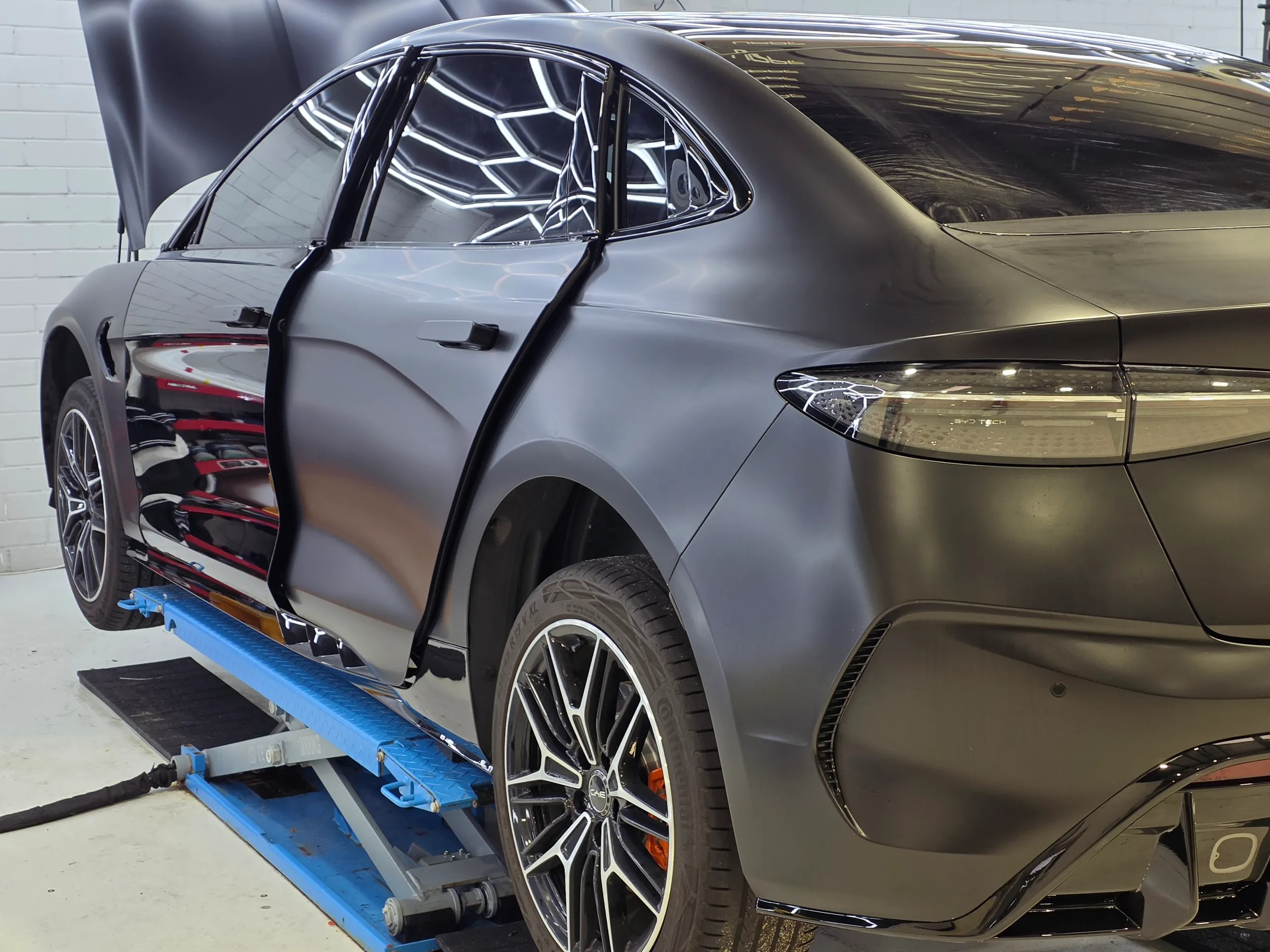 BYD Seal during satin conversion with a door and bonnet open and some panels still glossy